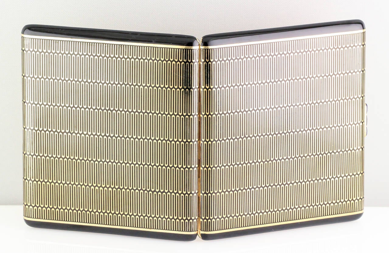 Masculine sapphire, 18K yellow gold and black enamel cigarette case by Cartier, circa 1930s-40s. Cabochon sapphires are set as the thumb-piece and are a high quality rich blue in color.  The enamel is in excellent condition.

Hallmarks: Cartier,