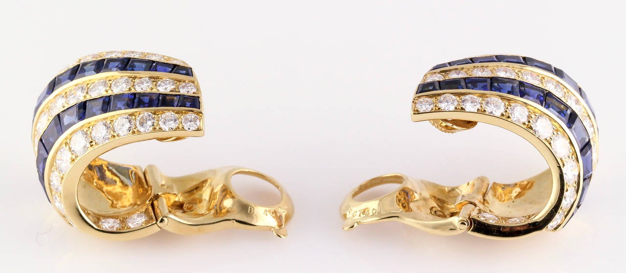 Chic diamond, sapphire and gold hoop earring by Van Cleef & Arpels, circa 1960s. They feature an inside out hoop design, with two small diamonds set in the back curvature of the hoop. Diamonds are very high grade round brilliant cut, approx.