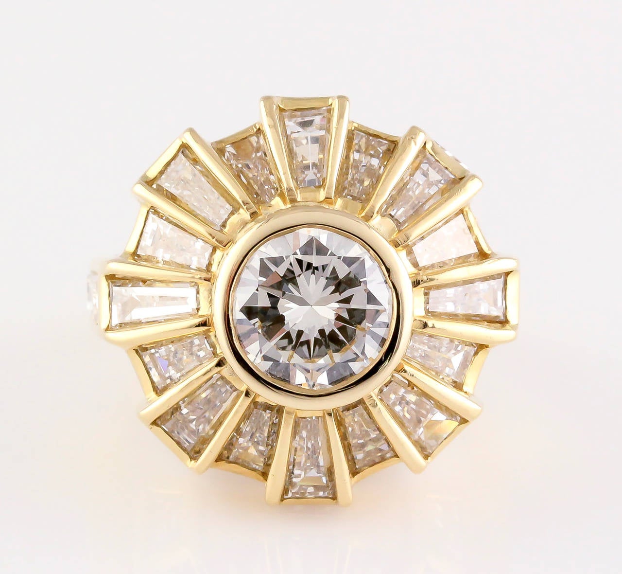 Stylish and edgy diamond and 18K yellow gold ring by Bulgari. It features very high grade round and an array of baguette cut diamonds. Central stone is approx. 1.75cts, near colorless white and VS clarity, with a total combined carat weight of