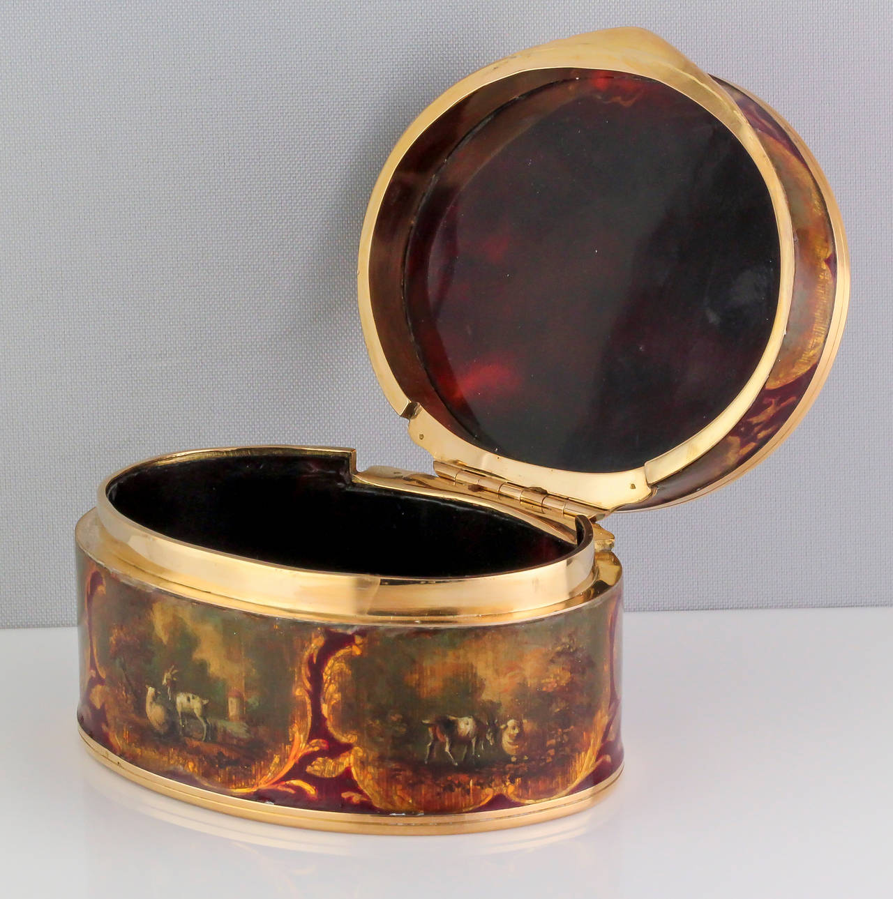 Rare et inhabituelle boîte à bijoux en or 18K, émail et coquillages d'origine française, vers le 19e siècle. Il est très orné, avec des représentations de paysages, d'animaux de la ferme, un garçon jouant de la flûte en bas, et un pique-nique tout