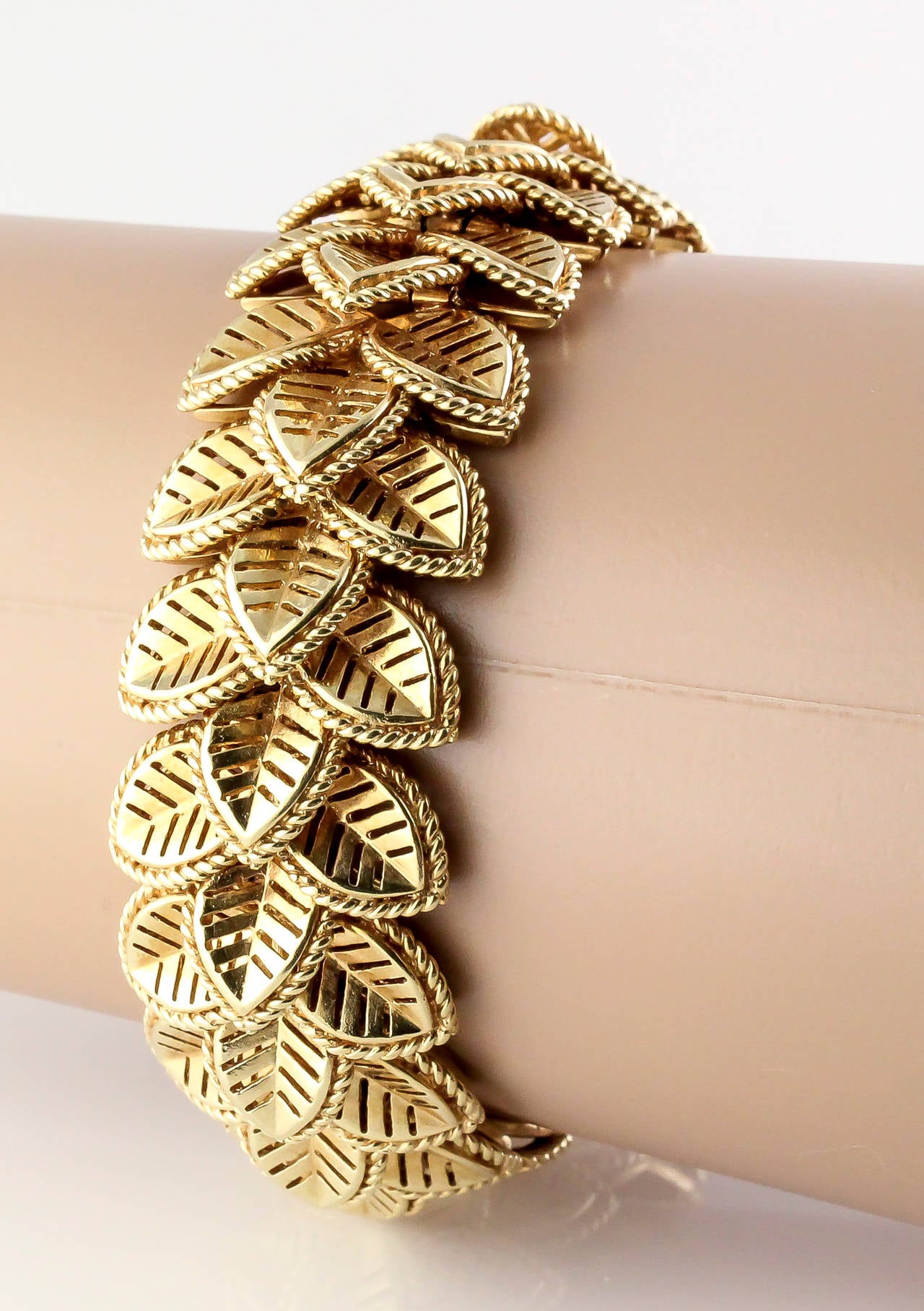 Intricate and unusual 14K yellow gold multi leaf bracelet by Cartier, circa 1950s. Each link on this exquisite bracelet is made up of three leaves with twisted rope borders. Flexible and easy to wear. 

Hallmarks: Cartier, 14K, reference numbers.