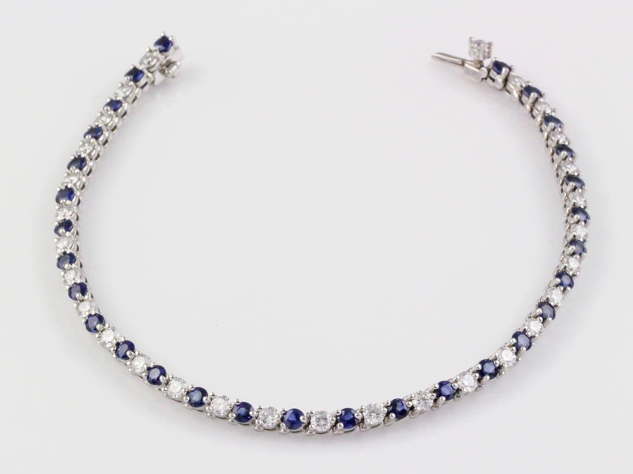 Elegant blue sapphire, diamond and platinum line bracelet by Tiffany & Co. This exquisite piece features very high grade round brilliant cut diamonds of approx 2.0 carats, as well as rich blue sapphires of approx 2 carats as well. Excellent