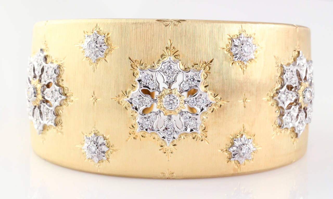 Impressive diamond and 18K yellow gold wide cuff bracelet by Mario Buccellati. It features their trademark Florentine finish, beautifully done throughout. Further accentuating it are the high grade round cut diamonds. Ultra stylish and refined cuff