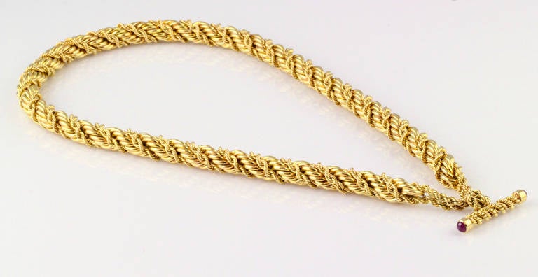 Intricate and unusual toggle necklace designed as a large rope with a smaller rope intertwined within it, by Tiffany & Co. Schlumberger. The toggle bar features two cabochon rubies at its ends. 

Hallmarks: Tiffany, Schlumberger, 18k.