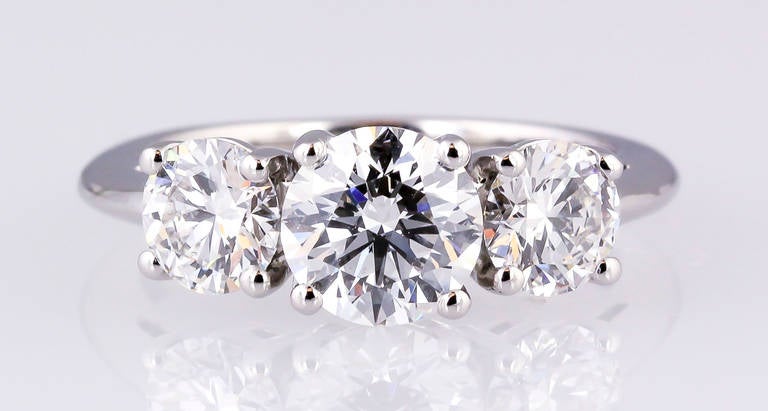 Timeless platinum-set diamond 3 stone engagement ring by Tiffany & Co. Diamonds are very high grade. Center stone is 1.02cts VVS2 clarity, F color. Size of side stones are .45 and .46cts F-G color, VVS1-VVS2. Size 4.75 (can be sized slightly up or