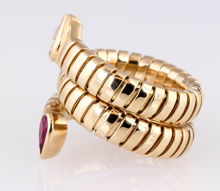 Elegant 18K yellow gold, diamond and ruby ring from the "Tubogas" collection by Bulgari. This is the double headed style ring. Diamond is very high grade pear shaped, and the ruby is rich red in color. Flexible ring so size is anywhere