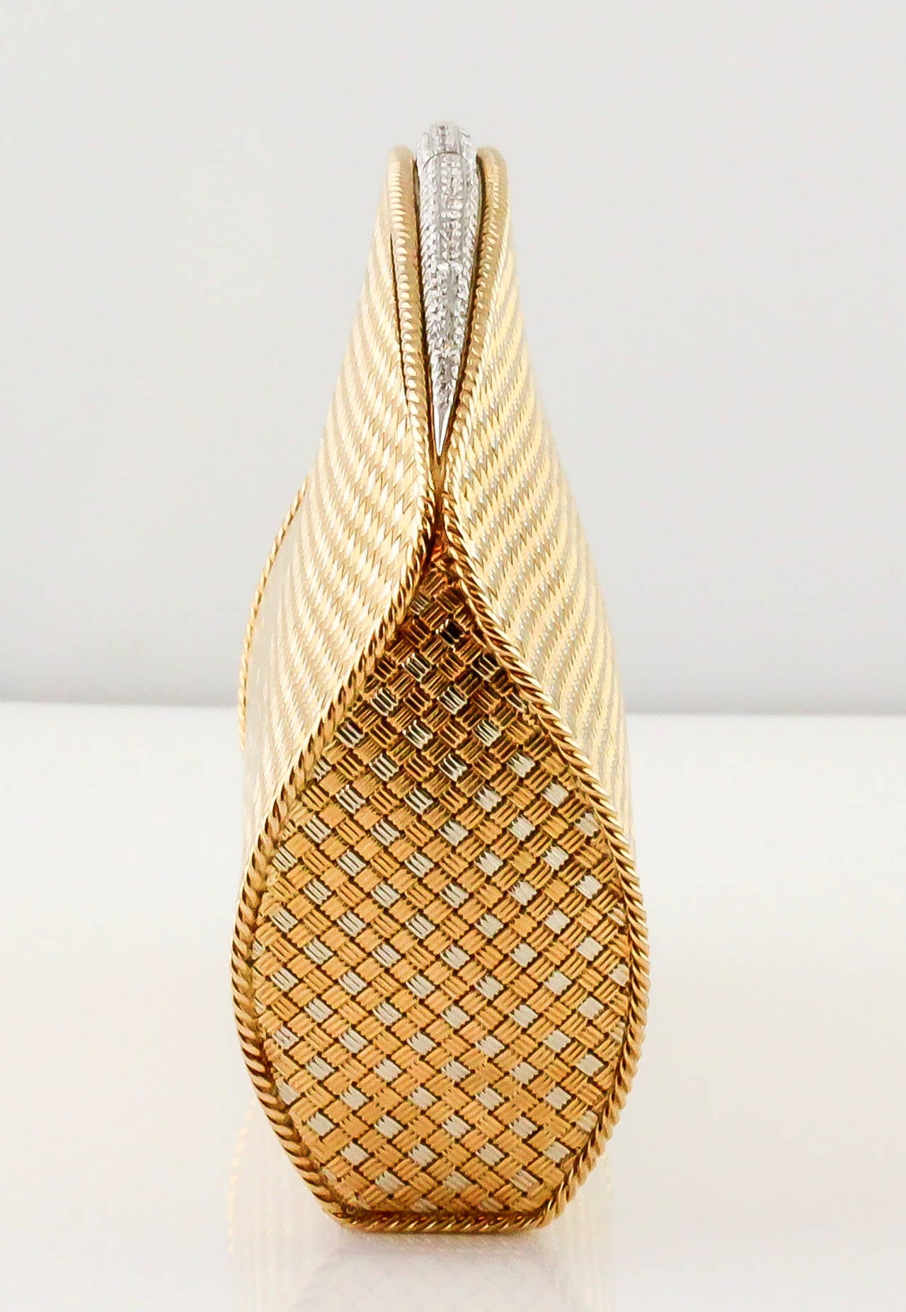 Rare and unusual 18K white and yellow gold and diamond clutch bag by Bulgari, circa 1960-70s. It features a basket weave design, with a twisted rope details around the edges. The top features very high grade round brilliant cut diamonds, approx. 6.0