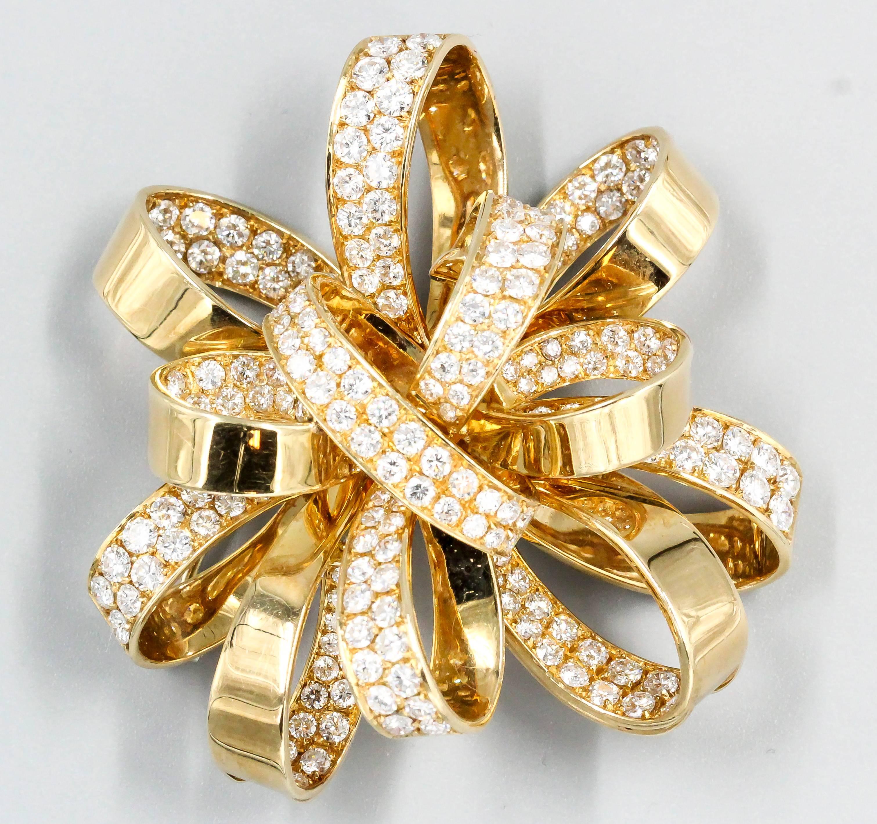 Chic diamond and 18k yellow gold ribbon brooch of Italian origin, previously owned by Estee Lauder of the cosmetics mega brand. It features approx. 6.0cts of high grade round brilliant cut diamonds, alternating between the inside and outside of each