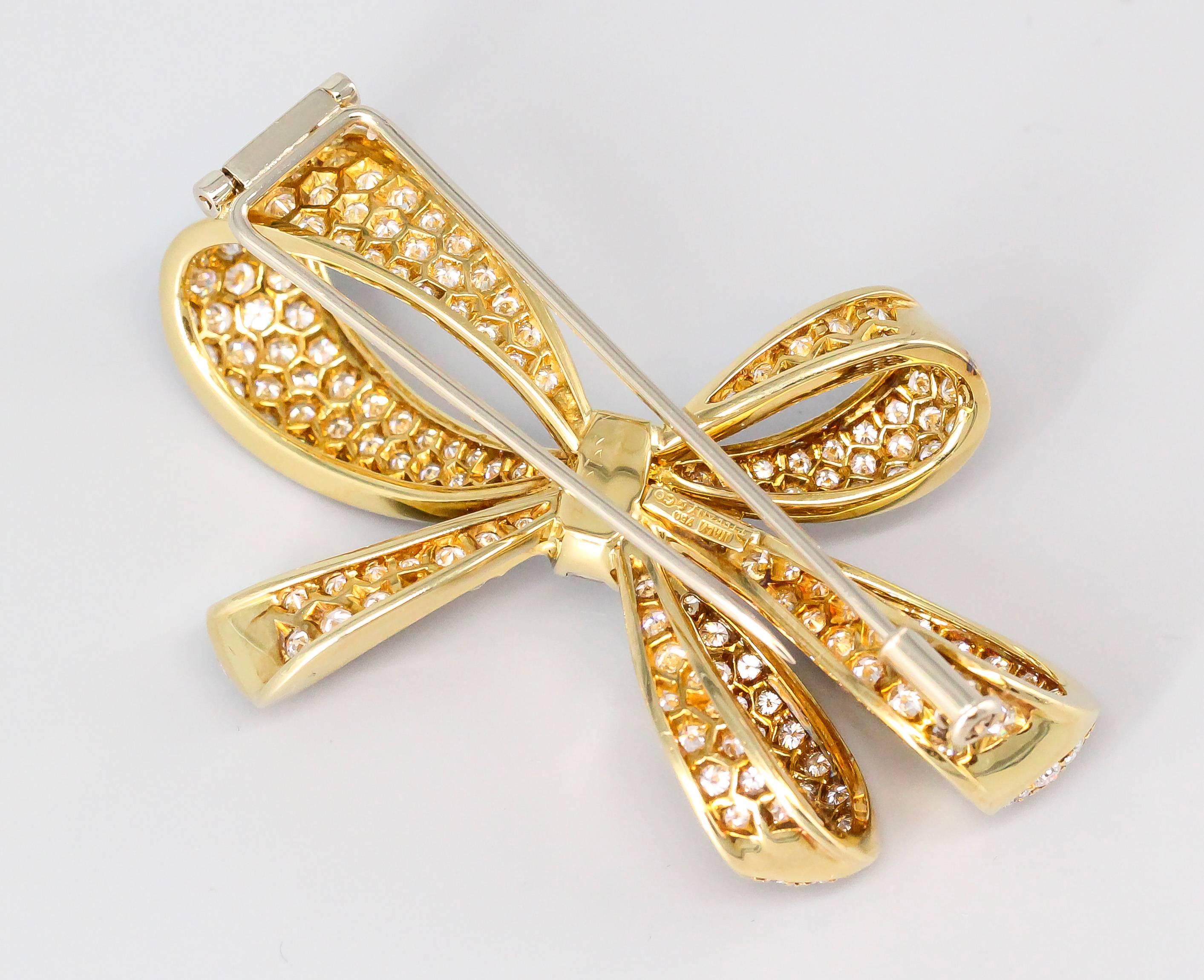 Elegant pave set diamond and 18K yellow gold brooch by Tiffany & Co. This beautifully made brooch features very high grade round brilliant cut diamonds in a pave setting and centers on a baguette cut diamond encrusted knot. Approx. 6.0 carats of