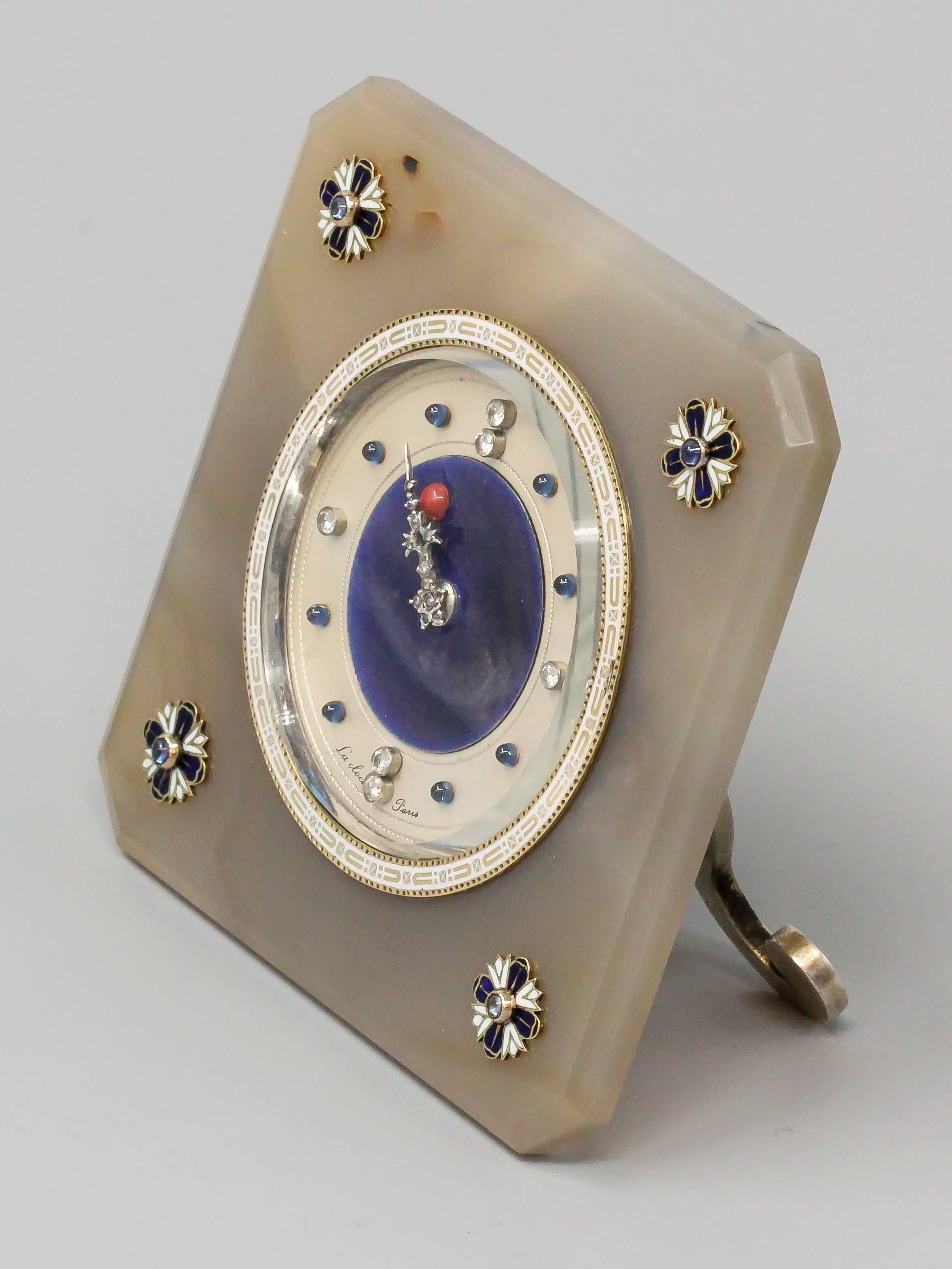 Very rare and unusual desk clock by Lacloche, circa 1920s. Clock features an agate body with white and blue enamel accented at each corner and cabochon blue sapphires on what we believe to be gold. Dial is beautifully made with blue enamel backdrop