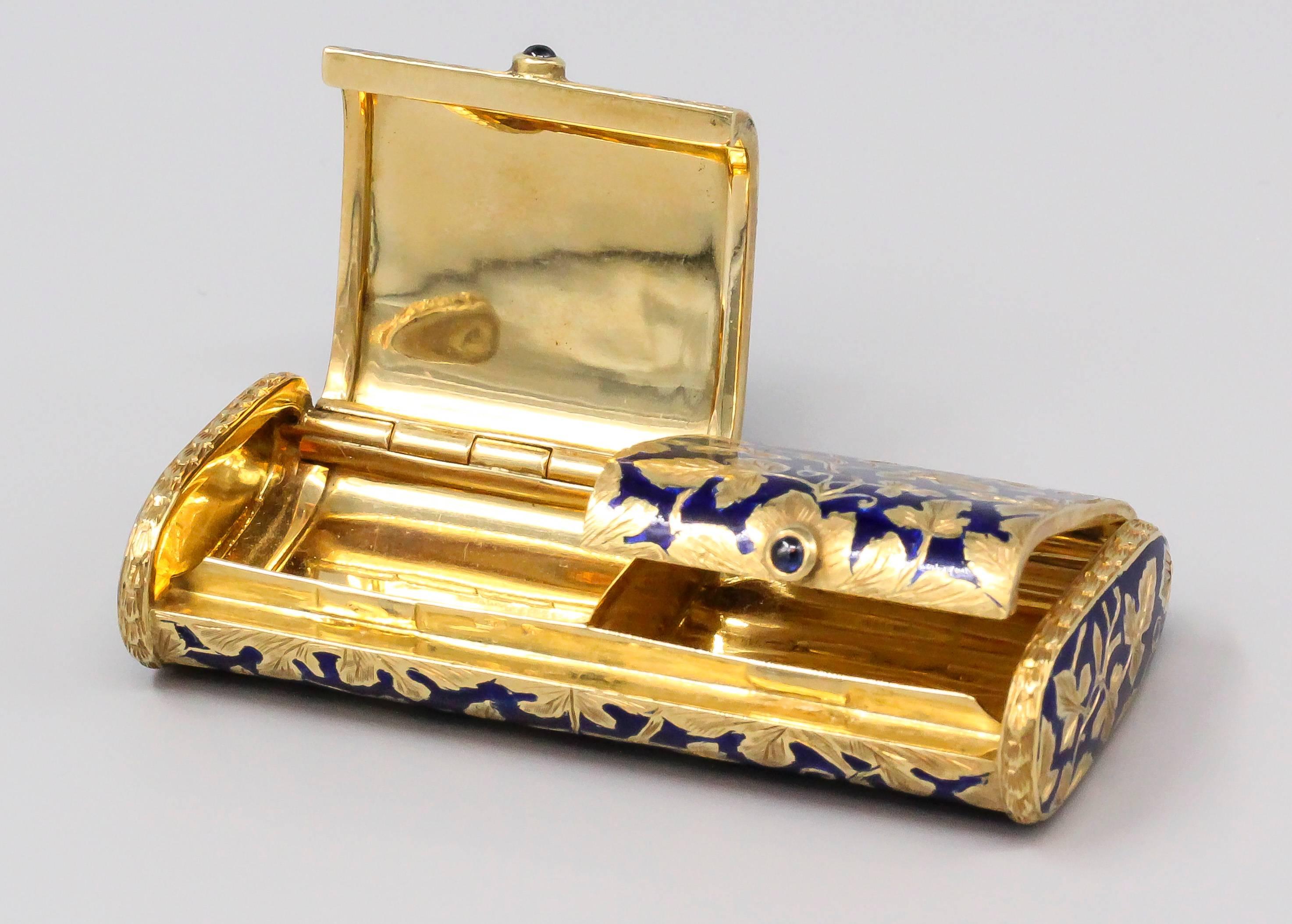 Charming blue sapphire, blue enamel and 18k yellow gold pill box of Italian origin. It features two rich blue cabochon sapphires opening each of the two separate compartments. Very ornate gold designs in the form of leaves over a blue enamel
