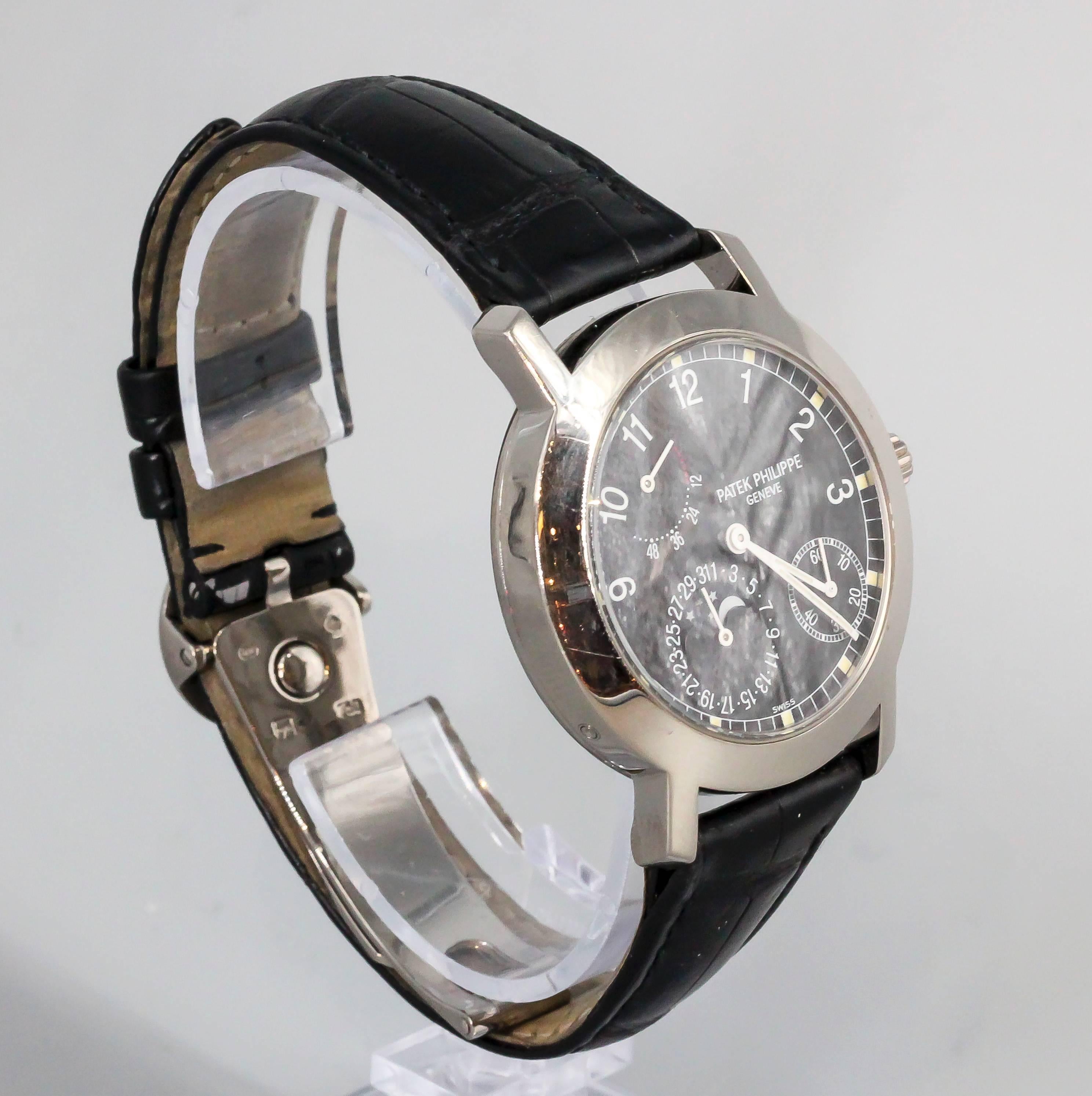 Elegant and refined 18K white gold wristwatch by Patek Philippe, reference #5055G. Highly intricate watch, with power reserve, moon phase calendar, date, and is a see-thru skeleton back watch featuring a very fine automatic movement. Comes with