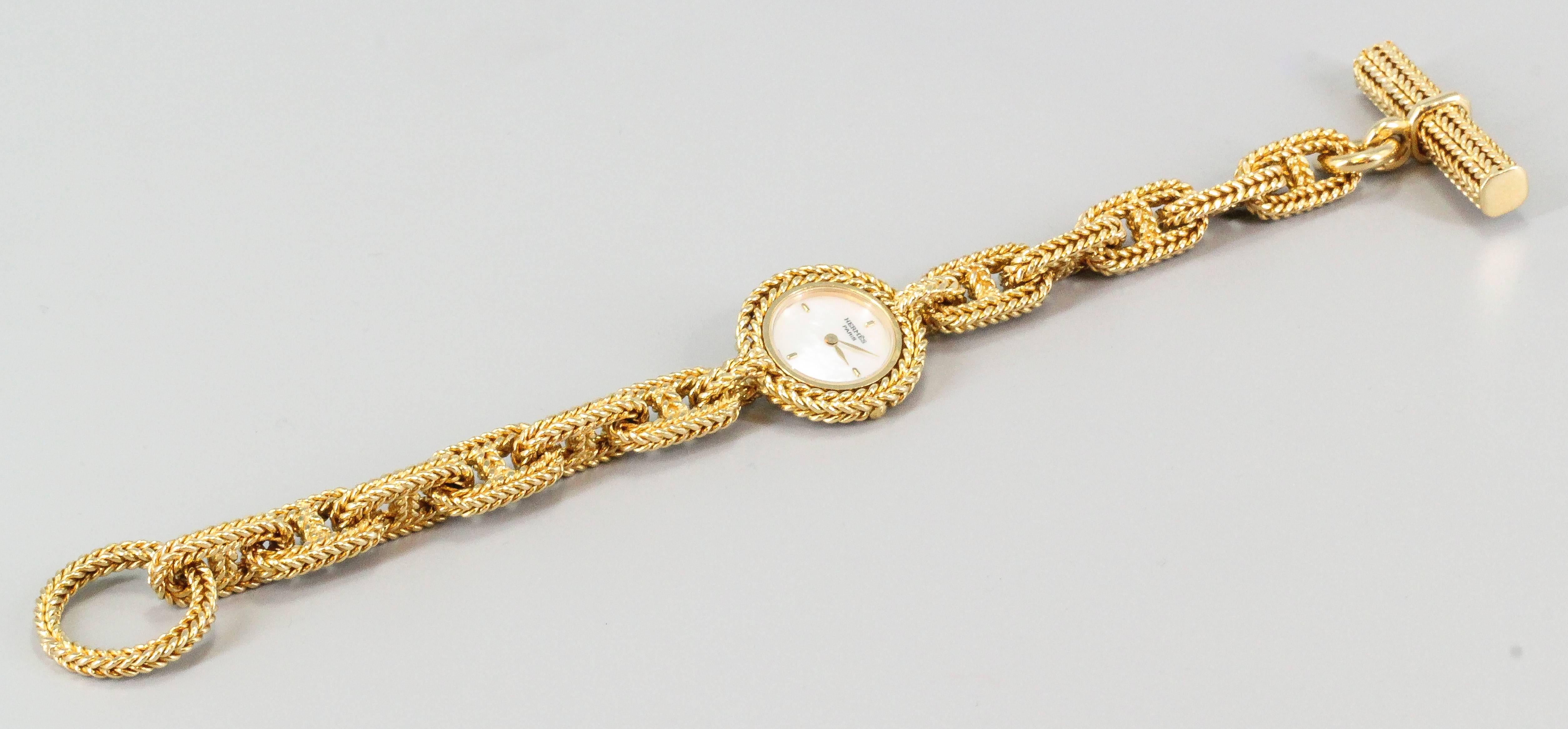 Fine and unusual 18K yellow gold toggle link bracelet watch from the "Chaine D'Ancre" collection by Hermes. Features a mother-of-pearl dial and a quartz movement. Beautifully made with expert workmanship. Rare in that it features the