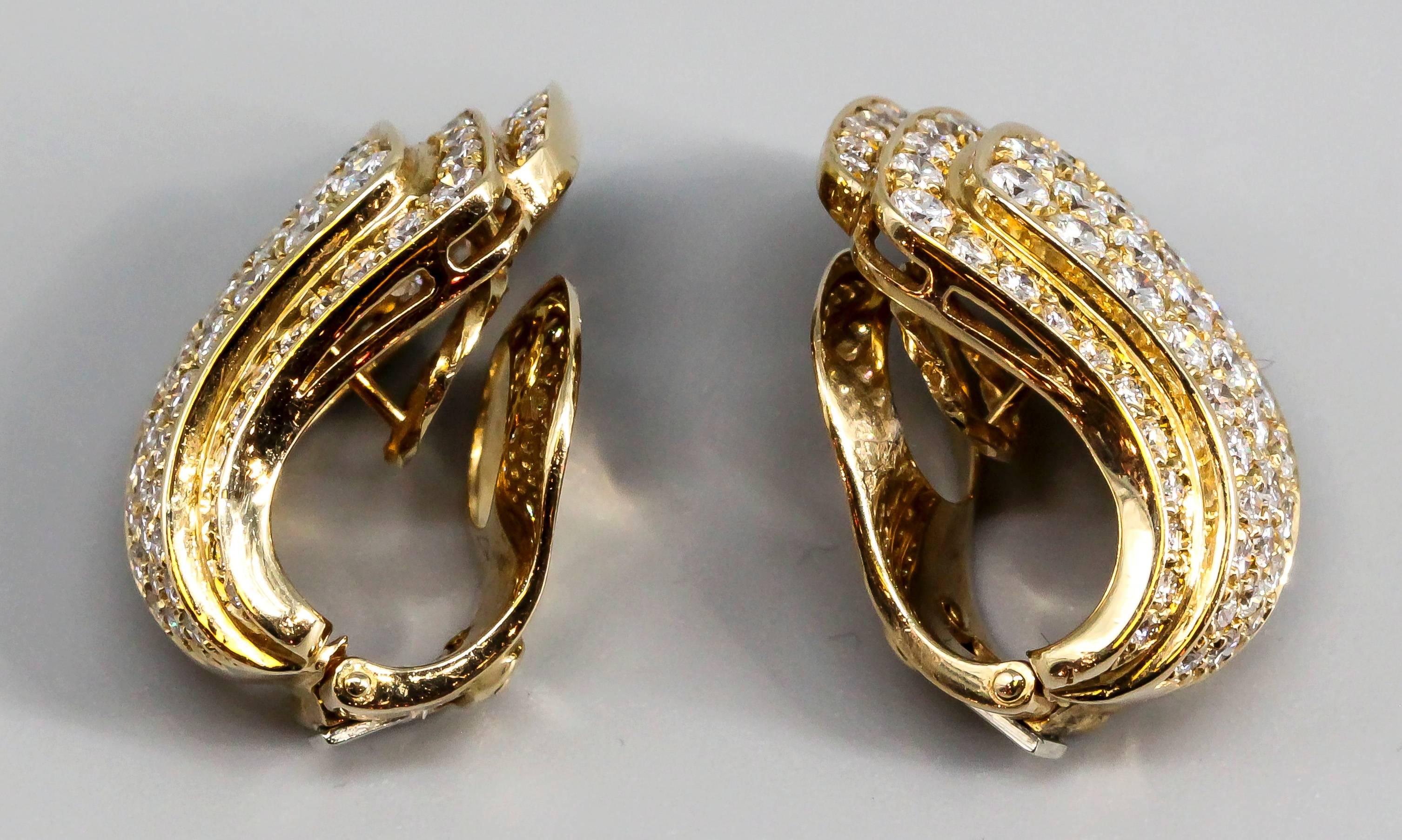 Elegant diamond and 18K yellow gold ear clips by Van Cleef & Arpels, circa 1960s-70s. They feature very high grade round brilliant cut diamonds, approx. 5.0 carats total weight. Excellent workmanship and a novel design.

Hallmarks: VCA, reference