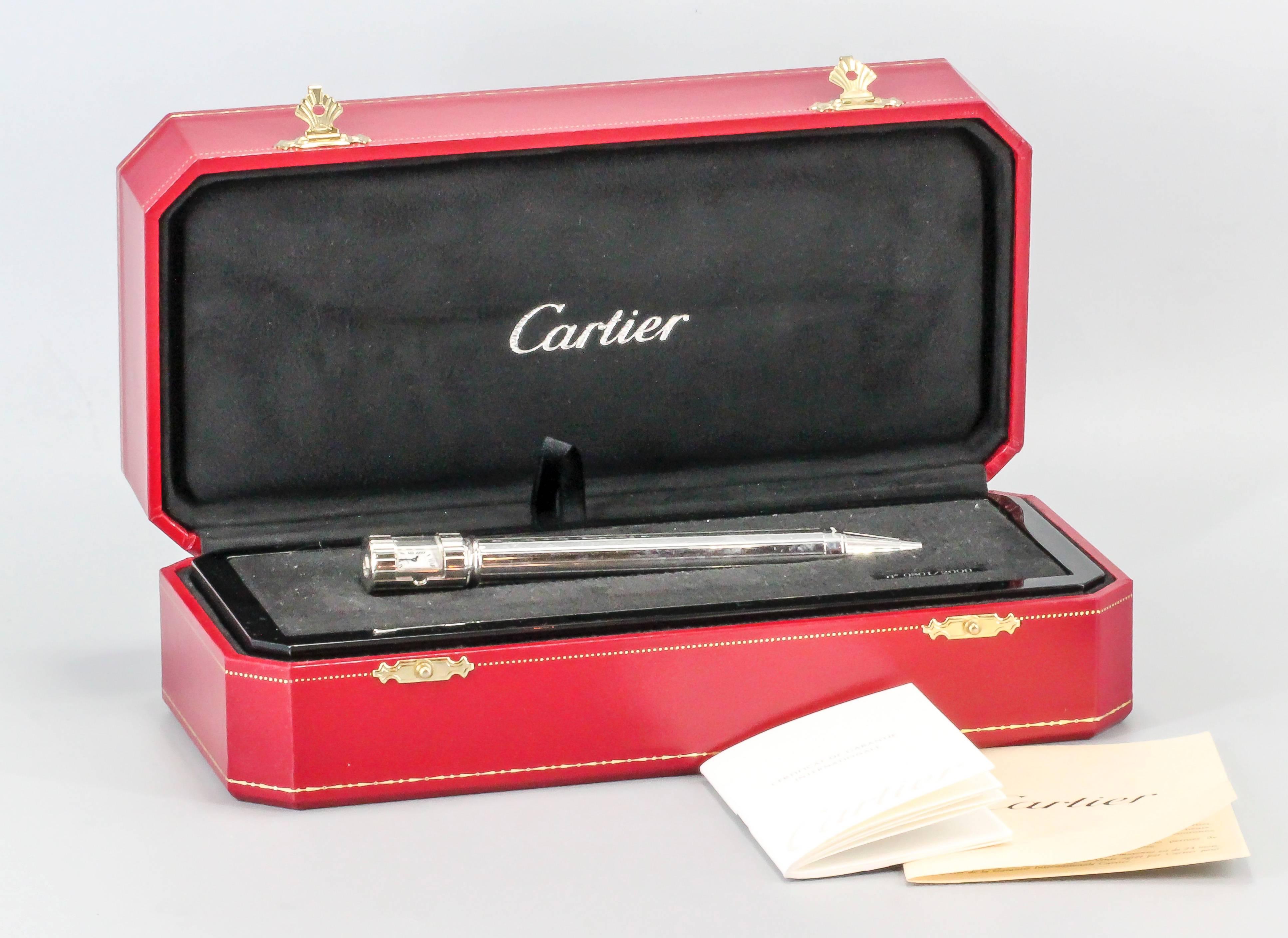 Handsome limited edition (#801 of 2000 made) clock/watch pen by Cartier. It features a twist action ballpoint pen with a small quartz movement watch at the very top, with roman numerals. Watch has a door that can conceal it when twisted. Comes with