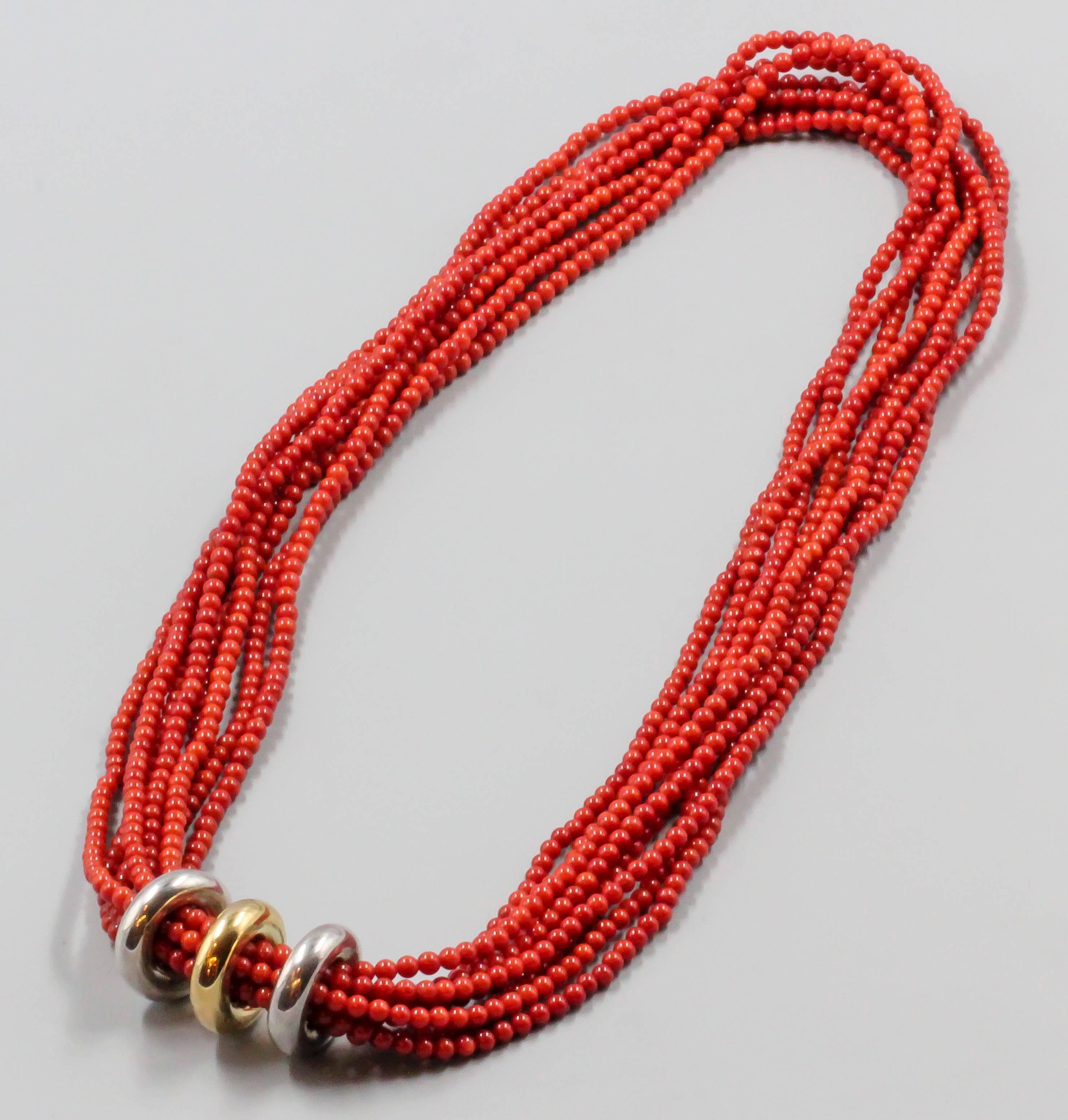Chic coral and white & yellow 18K gold necklace by Poiray. It features 8 strands of rich red coral , each bead approx 4mm diameter. Accentuated by a three piece rondelle, each of which can be moved and spaced separately. Beautifully made and very
