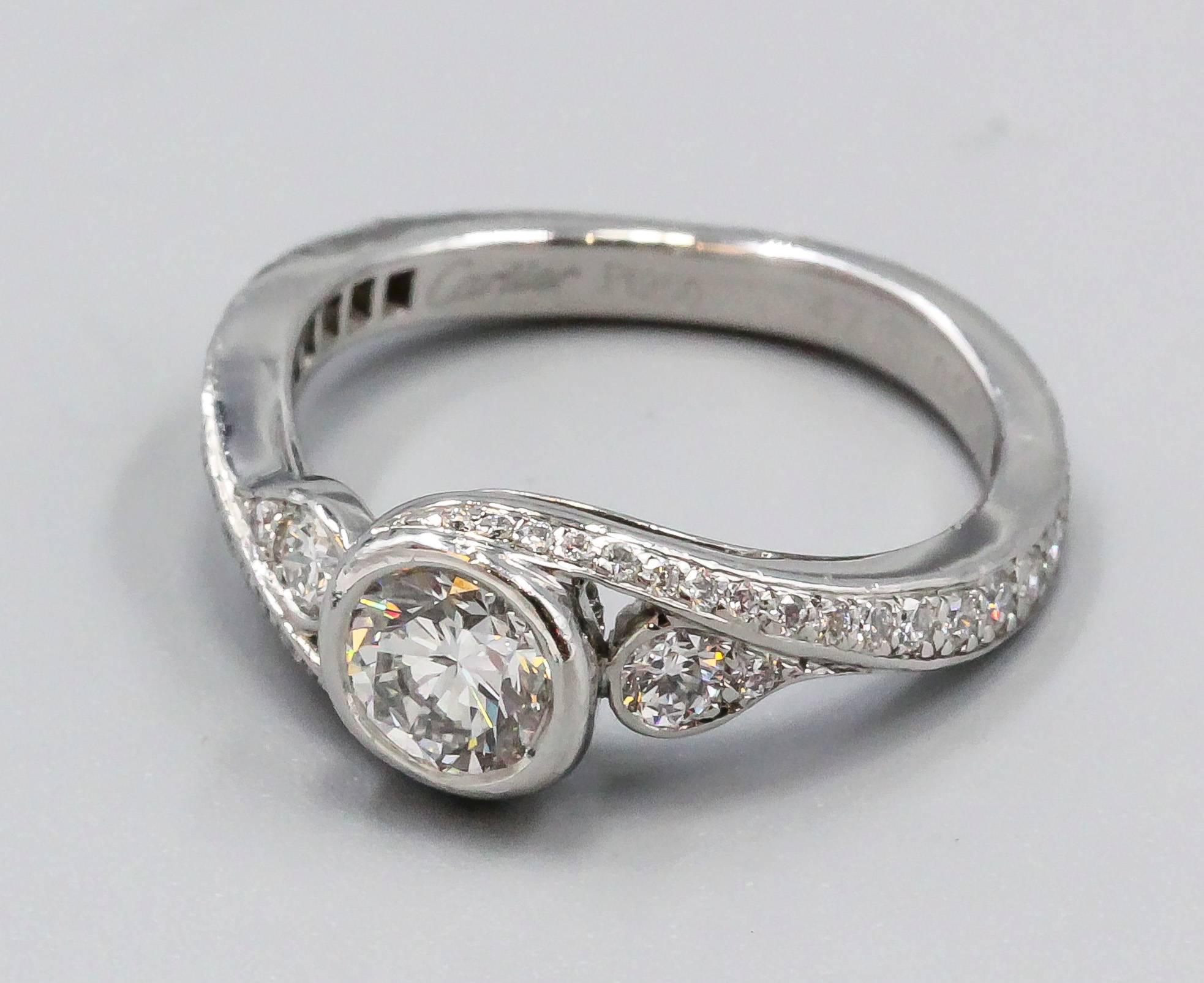 Absolutely charming diamond and platinum engagement ring by Cartier. It features a beautiful round brilliant cut central diamond,0.51, further flanked by high grade diamonds on each side. Size 47 European, approx. size 4, but can be made