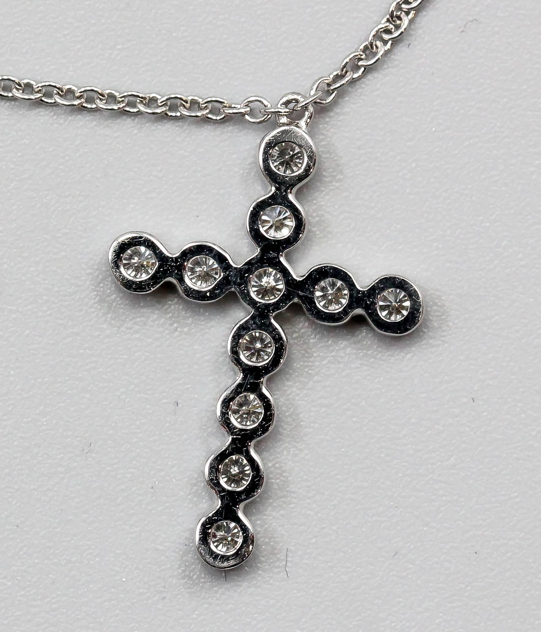 Elegant diamond and platinum cross pendant and chain by Tiffany & Co. Cross features high grade round brilliant cut diamonds. Chain is approx. 16