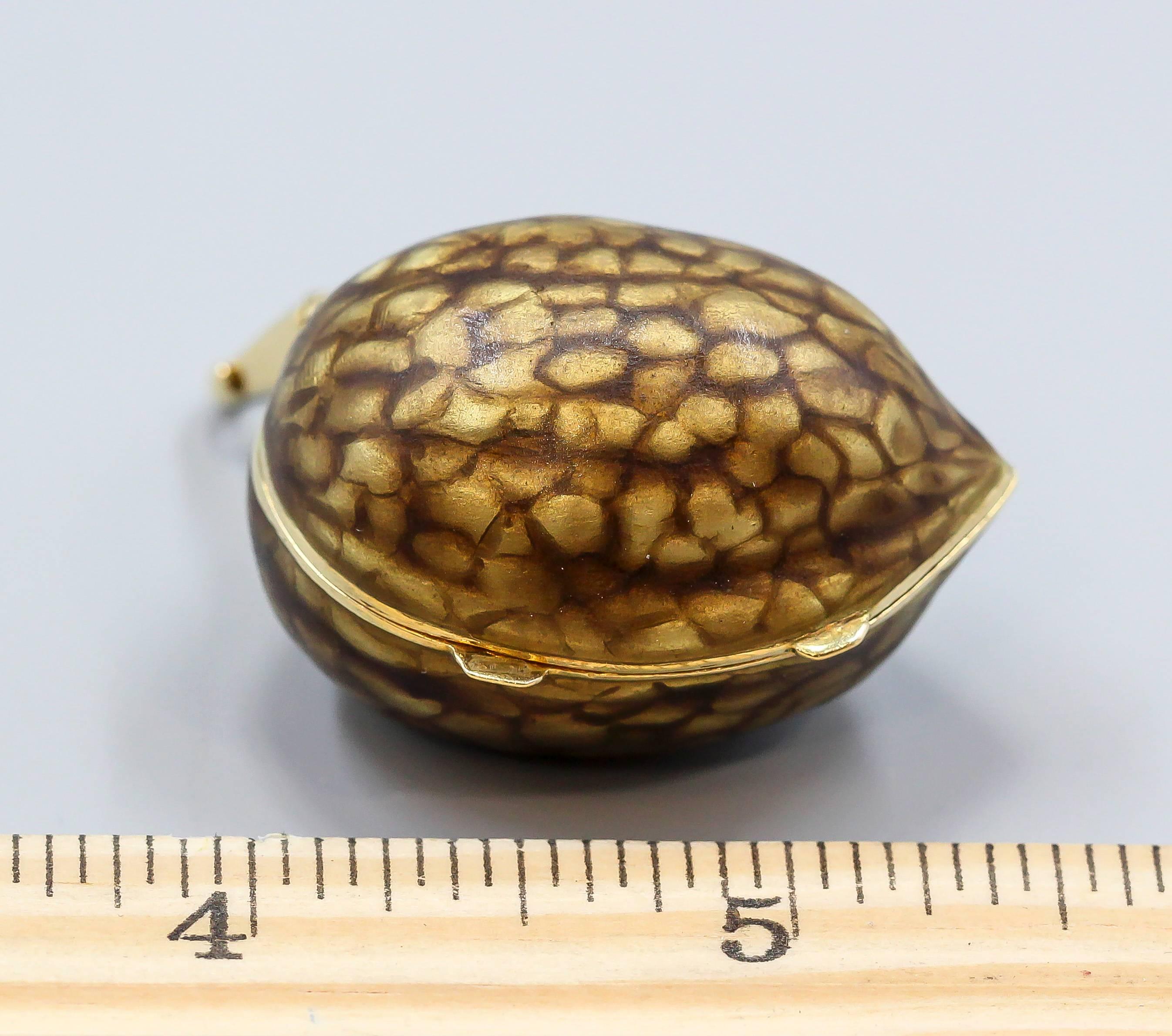 Unusual 18K yellow gold and enamel pill box with bale of Italian origin. It is in the shape of a walnut, with great attention to detail to make it look realistic. Comes with an 18K gold bale to attach it as a pendant or charm. High quality make and