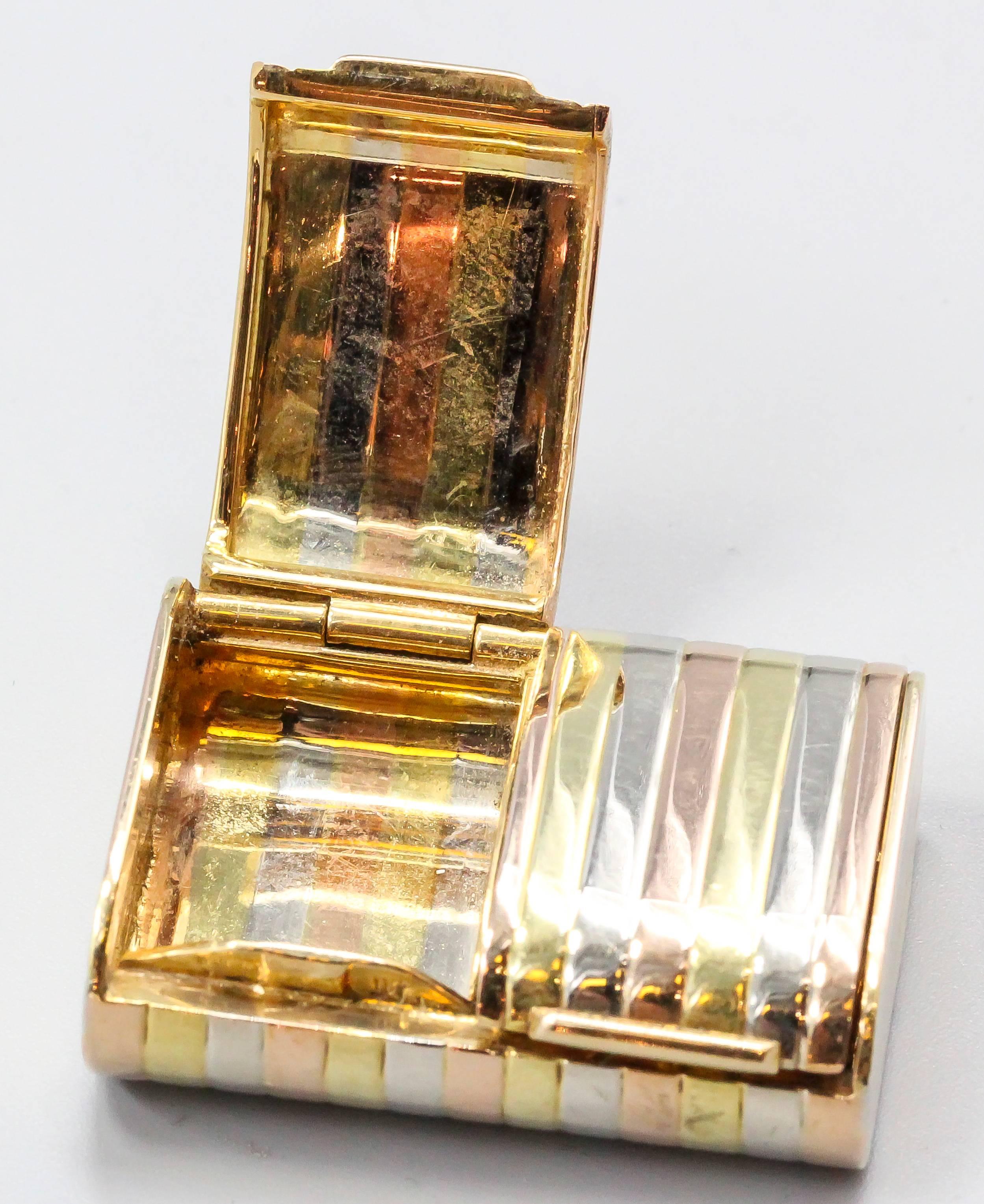 Elegant 18K yellow, white and rose gold pill box. It features two compartments. Beautifully made with a ribbed design.

Hallmarks: 18K.