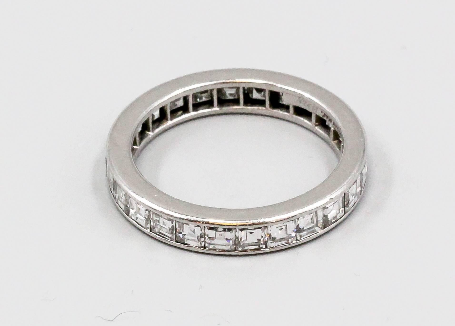 Timeless diamond and platinum band by Tiffany & Co., circa 1970s. It features high grade square cut diamonds, approx 2.5 carats. Great wedding/engagement gift. Excellent workmanship. Size 7.

Hallmarks: Tiffany & Co., Irid Plat.