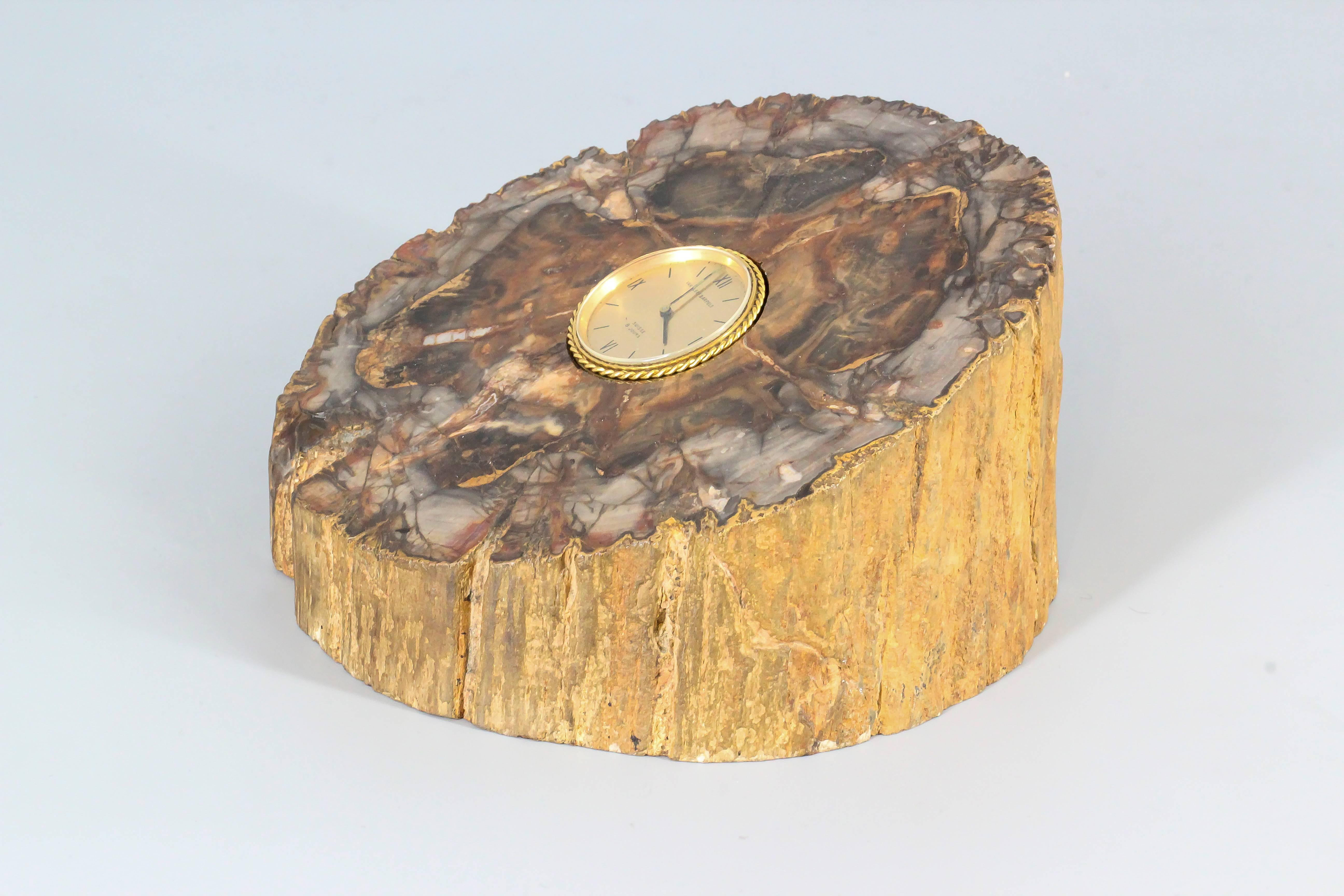 Rare and unusual 18K yellow gold desk clock by Van Cleef & Arpels set in petrified wood, circa 1970s. Mechanical watch movement. The watch itself can easily be removed from its base for easy winding.

Hallmarks: Van Cleef & Arpels, Suisse 8 Jours,