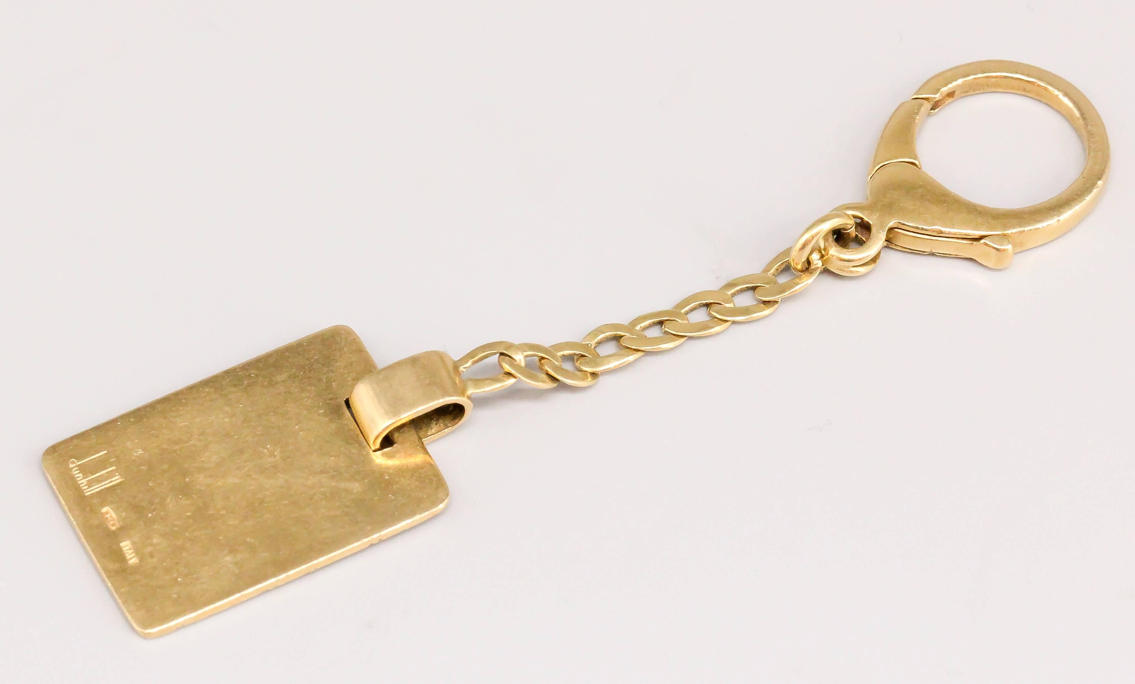 Handsome 18k yellow gold keychain by Dunhill, circa 1960s-70s. It features a rectangular shape with one side textured and the other polished smooth with space for personalized message. With small chain and hook for ease of installation on