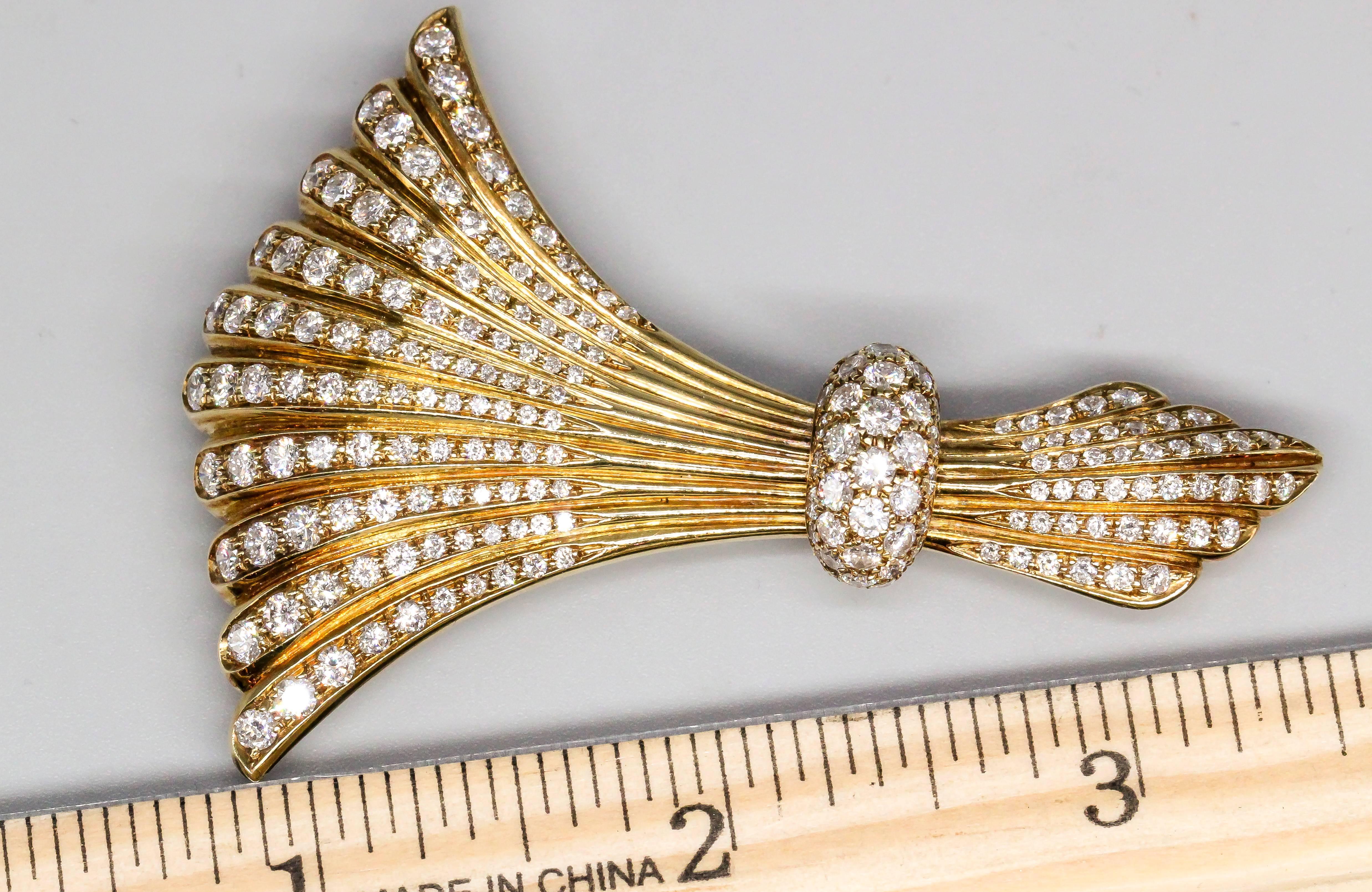 Elegant Mid-Century diamond and 18K yellow gold brooch and accessory piece of European origin. It features high grade round brilliant cut diamonds, over an impeccably made 18K yellow gold mounting. Very versatile, as it can be worn as a brooch by