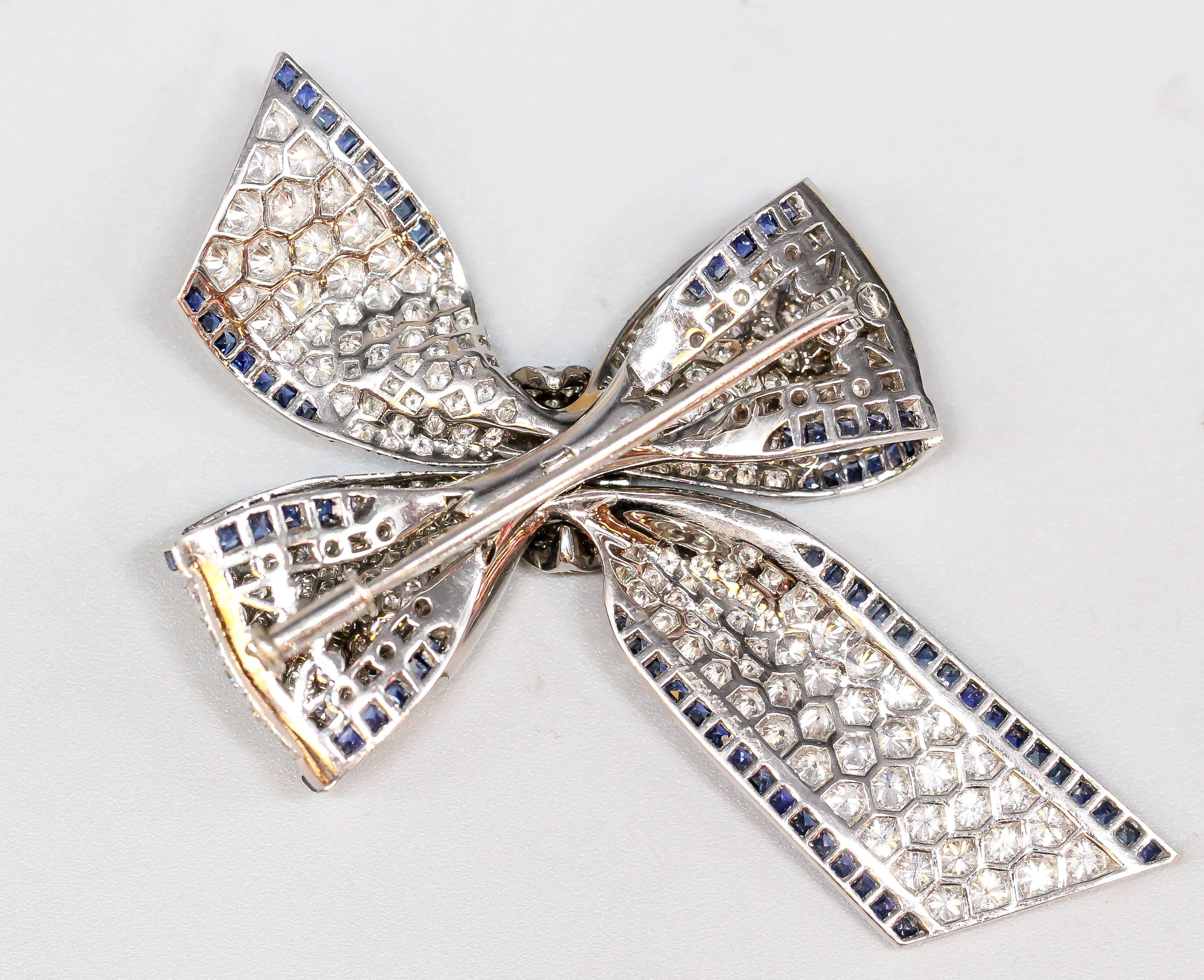 Chic brooch in the form of a bow, by Tiffany & Co. circa 1970s.  The wonderful brooch features a lifelike design, with calibre cut sapphire edges and a diamond pave.  This item consists of over 7 carats of high grade diamonds and sapphires. 