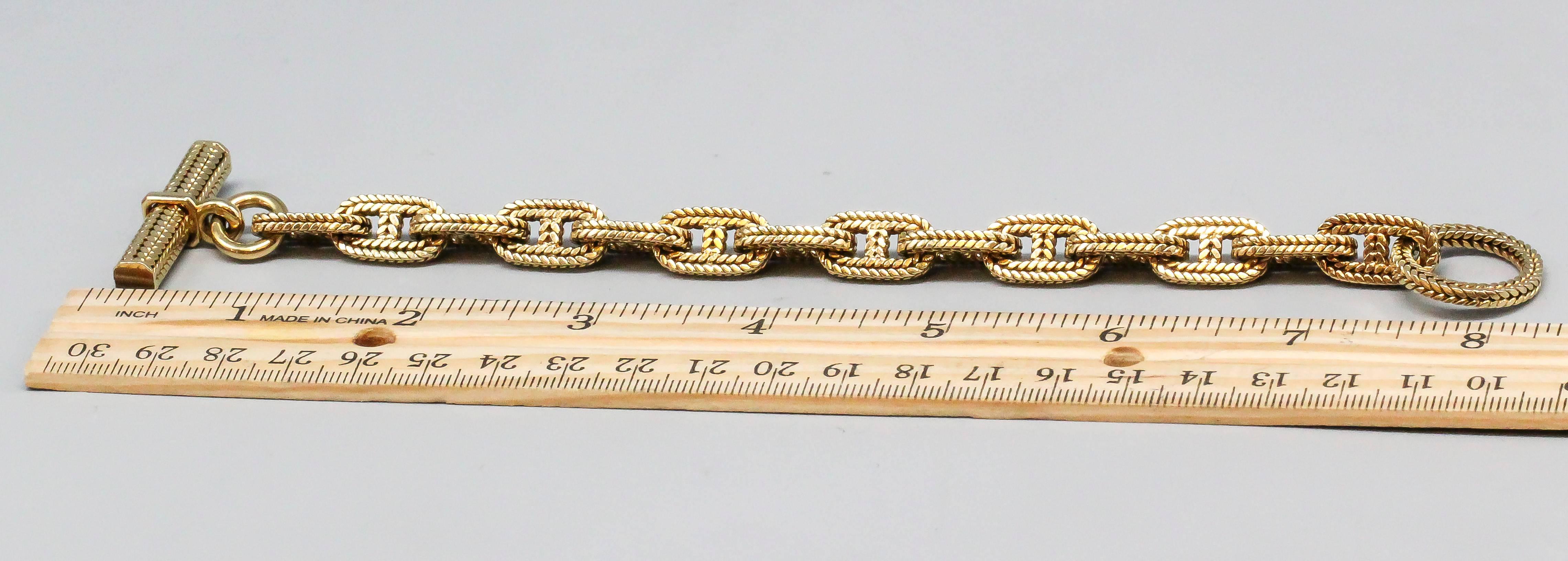 Timelessly elegant braided gold link bracelet by George L'Enfant for Hermes, circa 1960s. This classic bracelet shown is the medium size, weighing 68.1 grams and measuring over 8 inches in length.

Hallmarks: Hermes Paris, maker's mark (G L), and