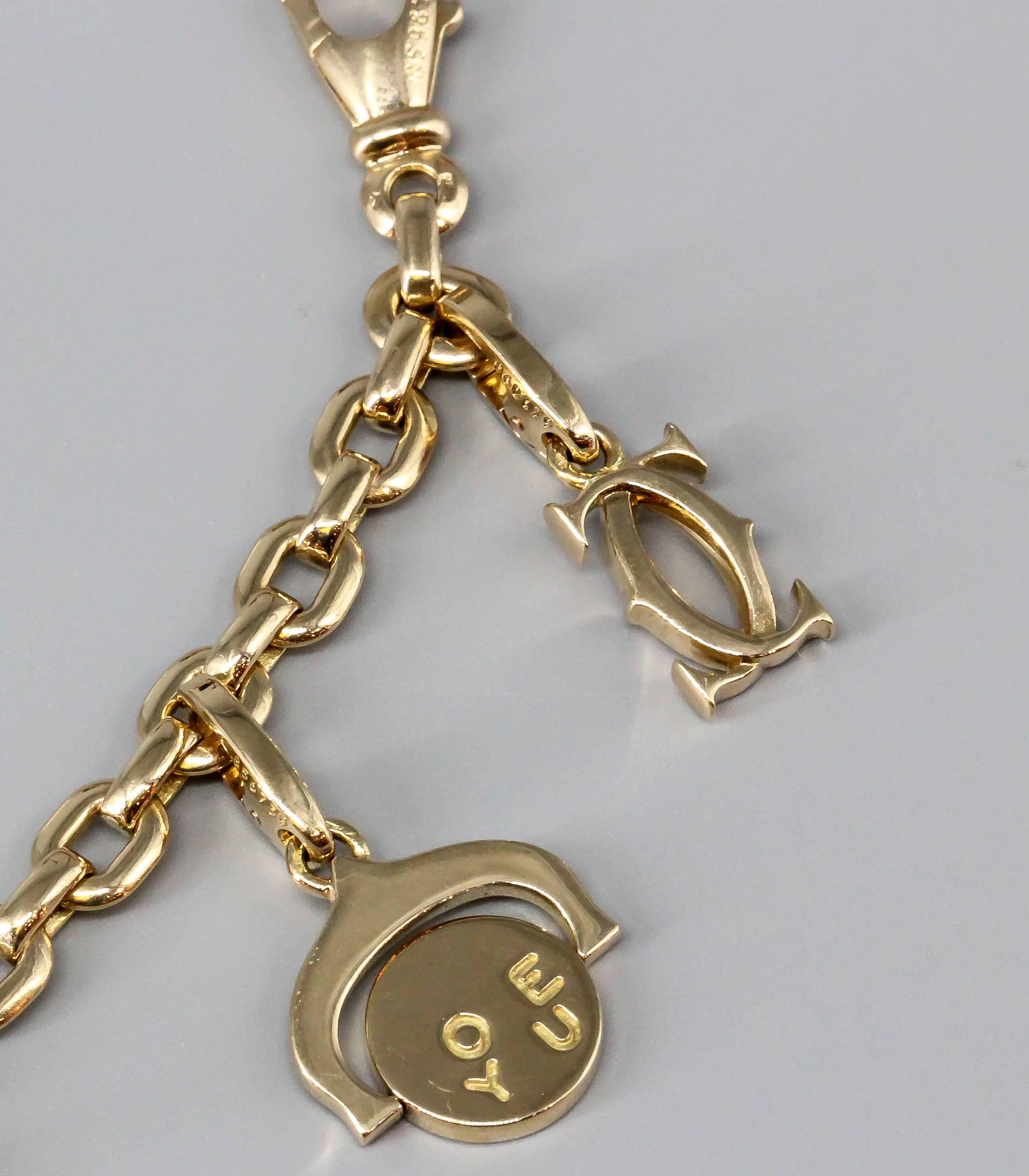 Exceptionally charming 18K yellow gold charm bracelet by Cartier. It features 10 charms, including: trinity ring, Cartier logo, Cartier logo with diamonds, I Love You flip charm, panthere, toy rocking horse, love bracelet, elephant, two-tone gold