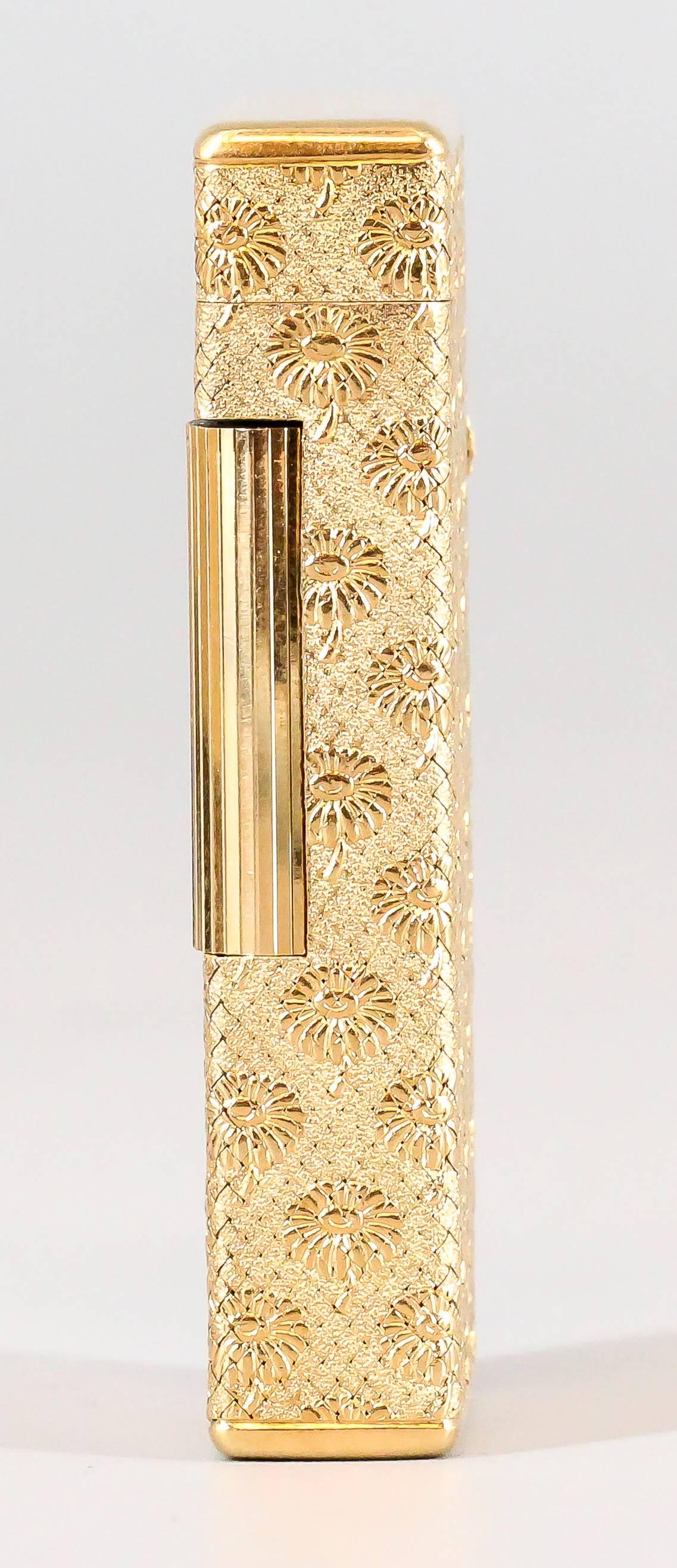 Rare 18K yellow gold lighter from the "Marguerite" collection by Boucheron, circa 1960s. It features a repeating flower design on all sides, resembling the Marguerite flower. Beautiful workmanship throughout.

Hallmarks: Boucheron,