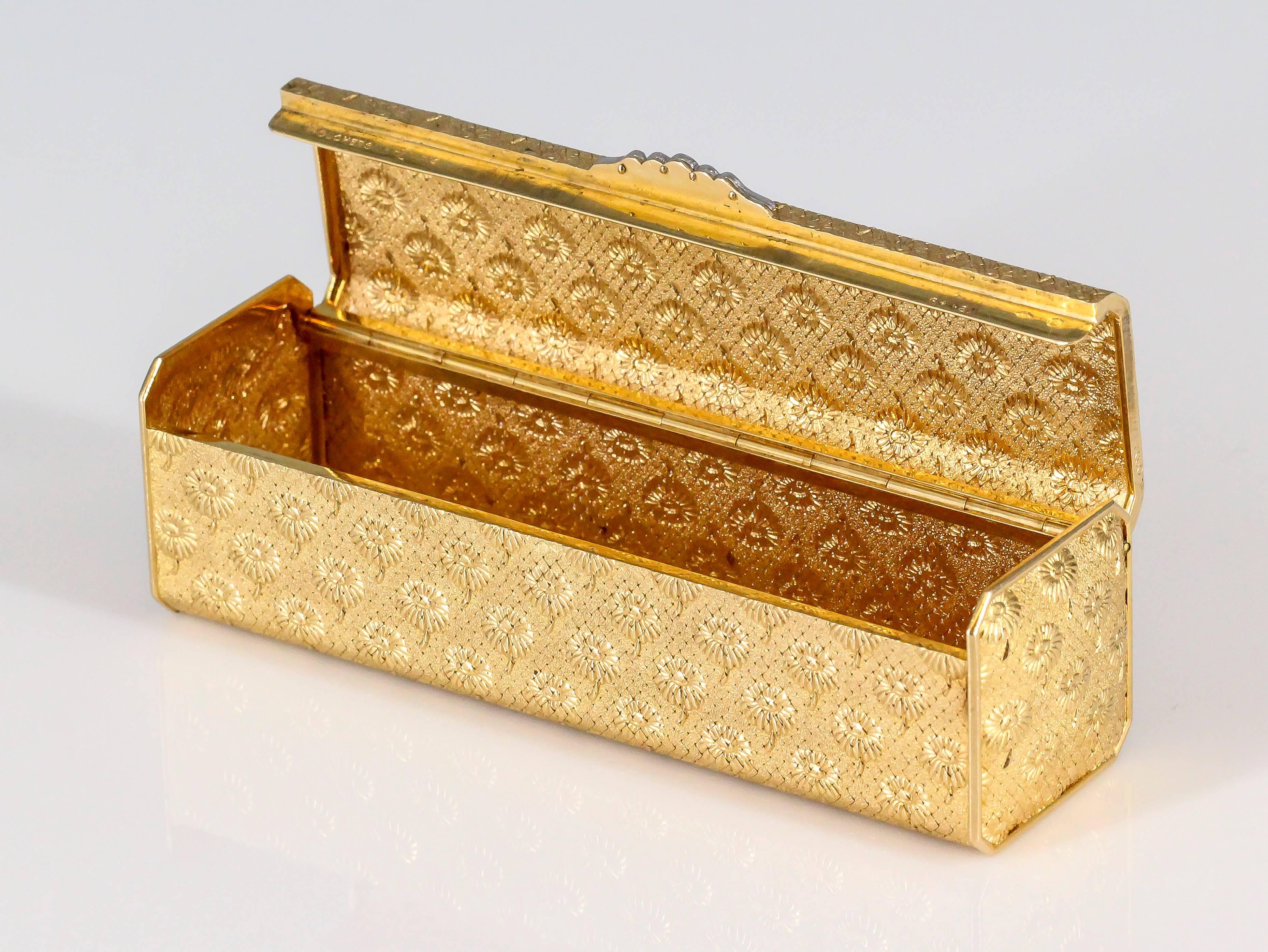 Elegant 18K yellow gold box from the "Marguerite" collection by Boucheron, circa 1960s.  The box can be used for pills or as a lipstick case, among other uses. It features a repeating flower motif resembling marguerite daisies throughout