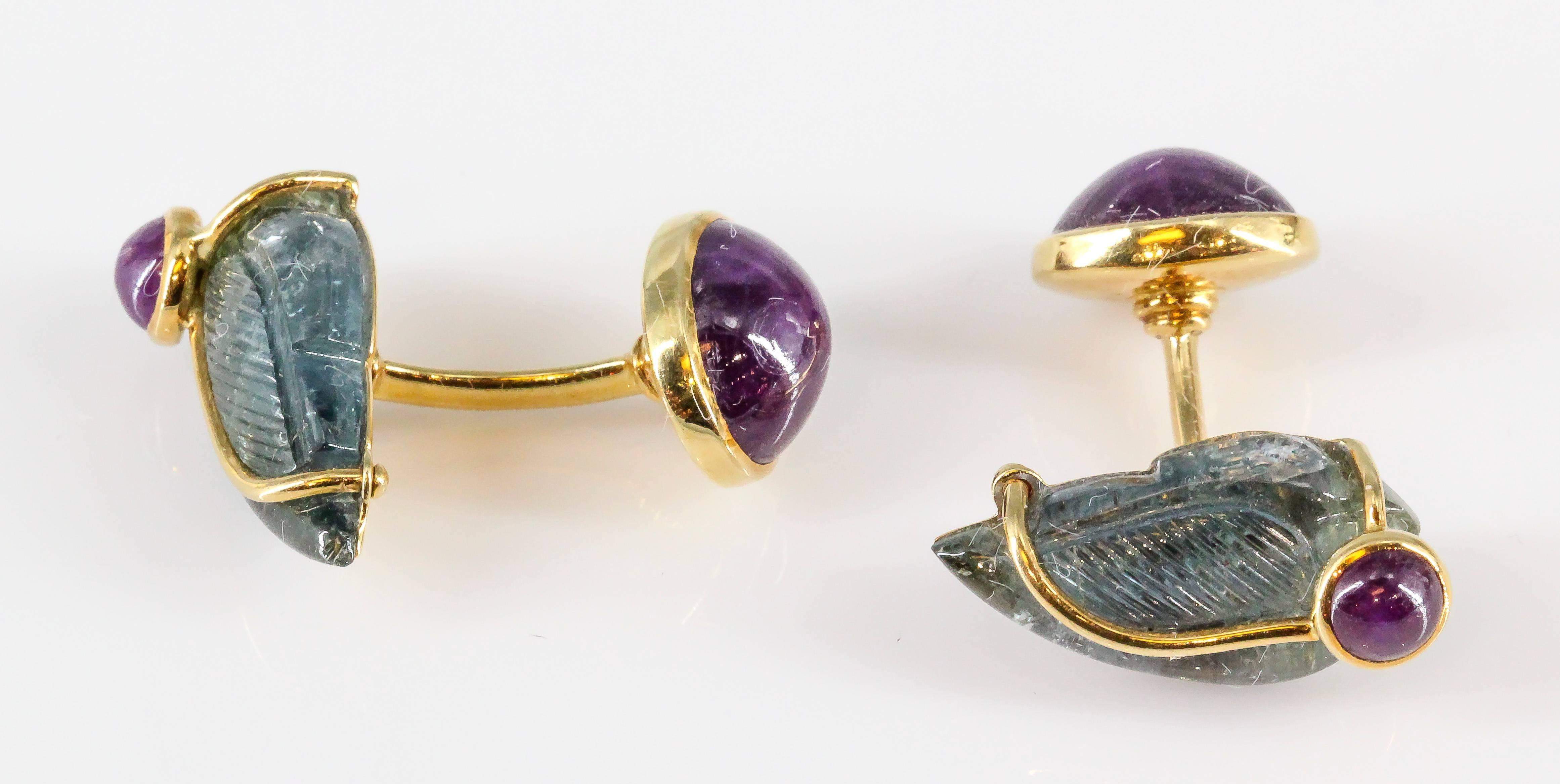 Elegant and unusual ruby, carved aquamarine and 18K yellow gold cufflinks by Seaman Schepps. They feature rich red cabochon rubies with a carved aquamarine resembling a wing. Beautifully made and easy to wear.

Hallmarks: Seaman Schepps, copyright,