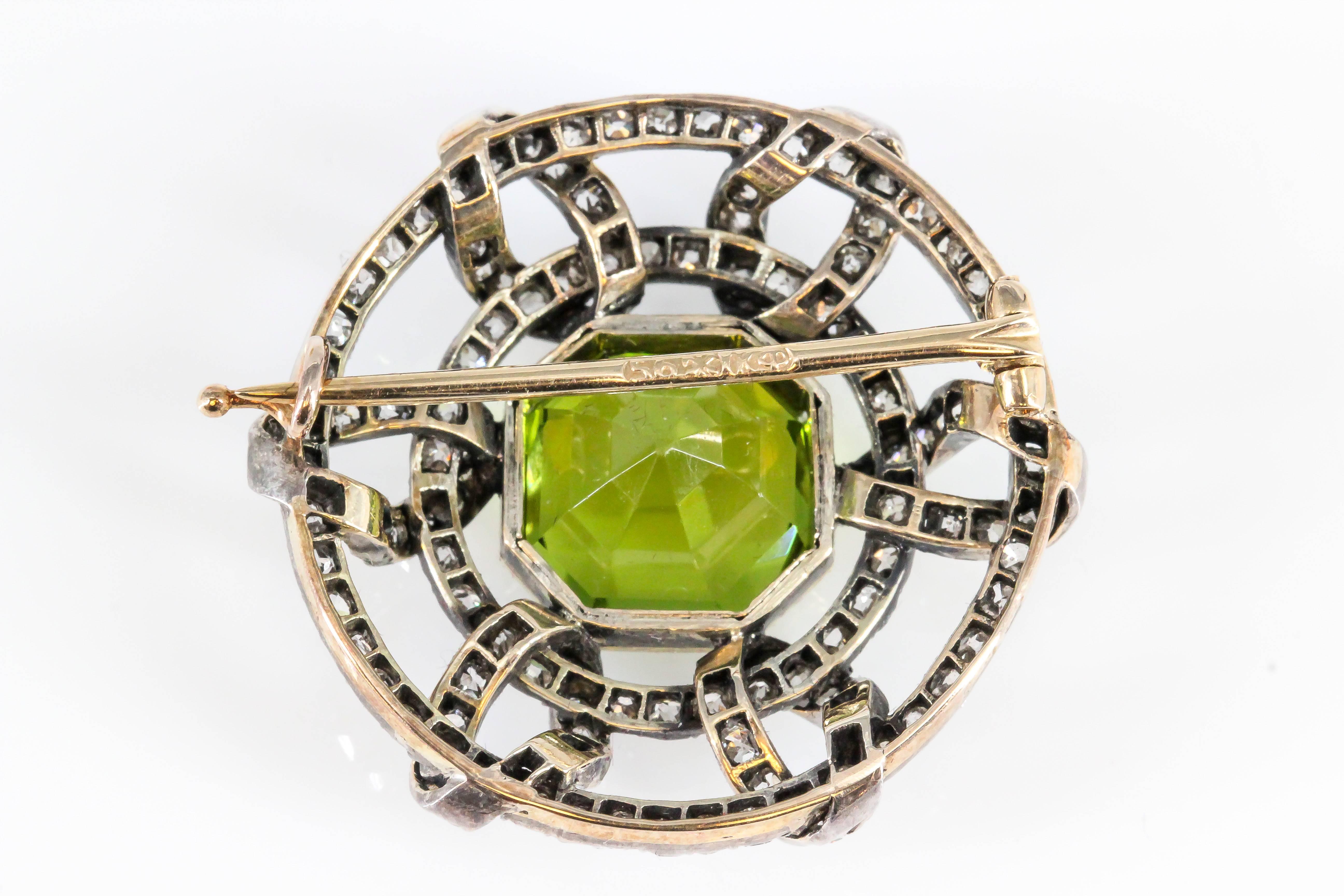 Rare and unusual peridot, diamond and 14K yellow gold brooch by Carl Faberge. The focal point is a richly colored peridot stone, approx. 19cts total weight, surrounded by high grade round brilliant cut diamonds over a 14K yellow gold