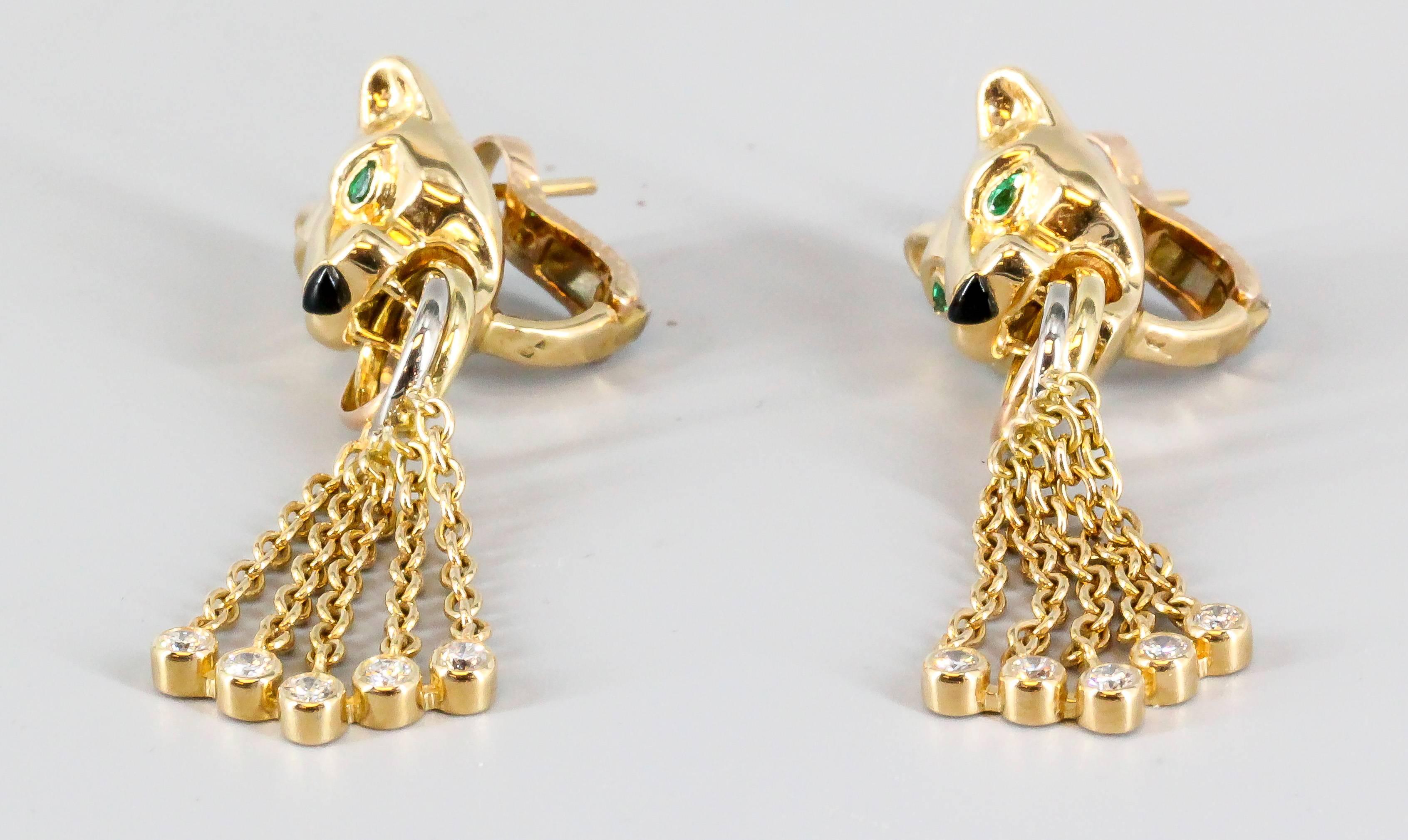 Fierce diamond, emerald, onyx and 18K yellow gold earrings from the Panther collection by Cartier. They feature high grade round brilliant cut diamonds, with the head of a panther with emerald eyes and an onyx nose. Beautifully made and highly