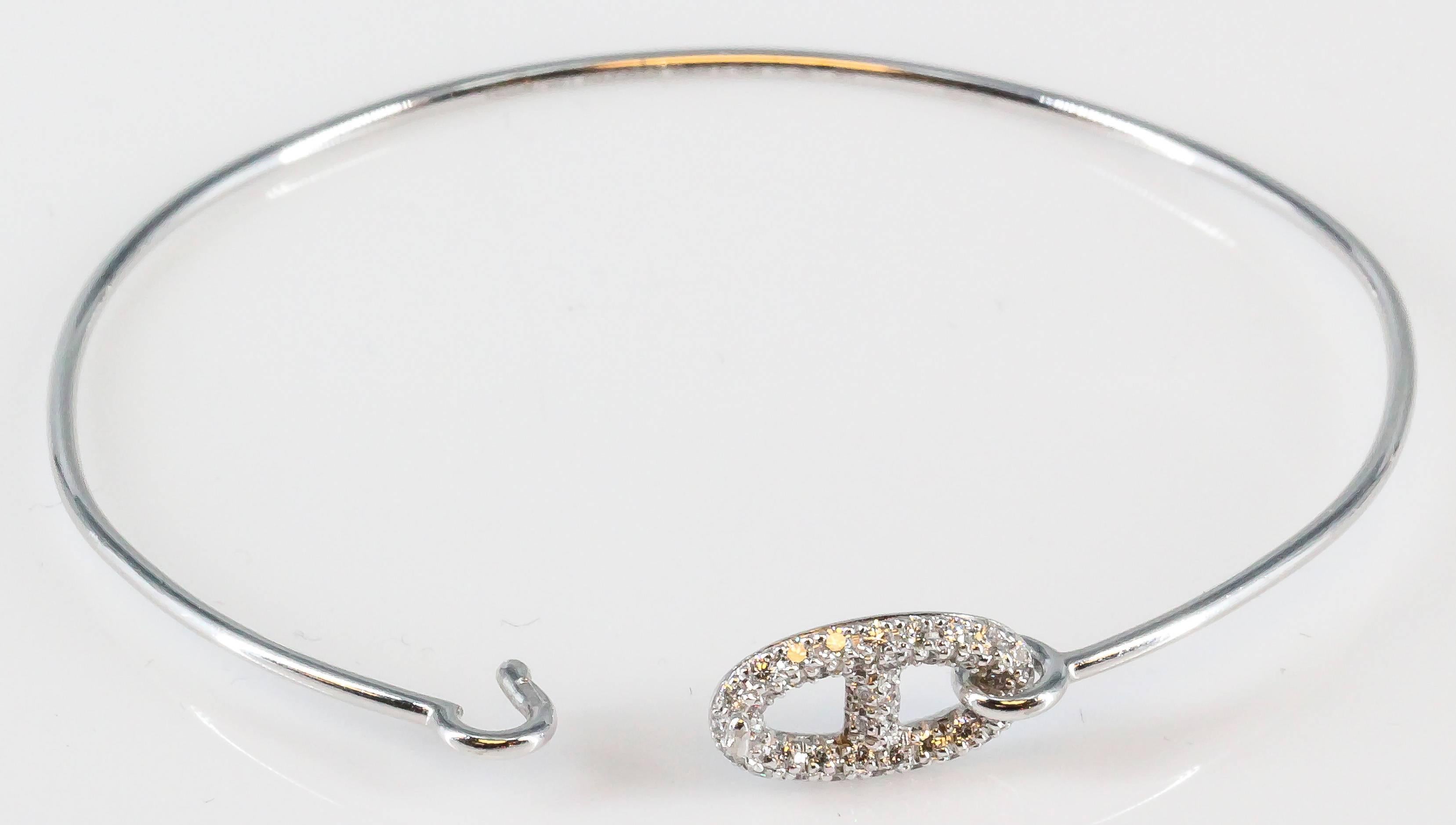 Refined diamond and 18K white gold bangle bracelet from the "ronde" collection by Hermes. It feature high grade round brilliant cut diamonds, approx. 0.32cts total weight. The design draws inspiration from a ship's anchor chain to create a