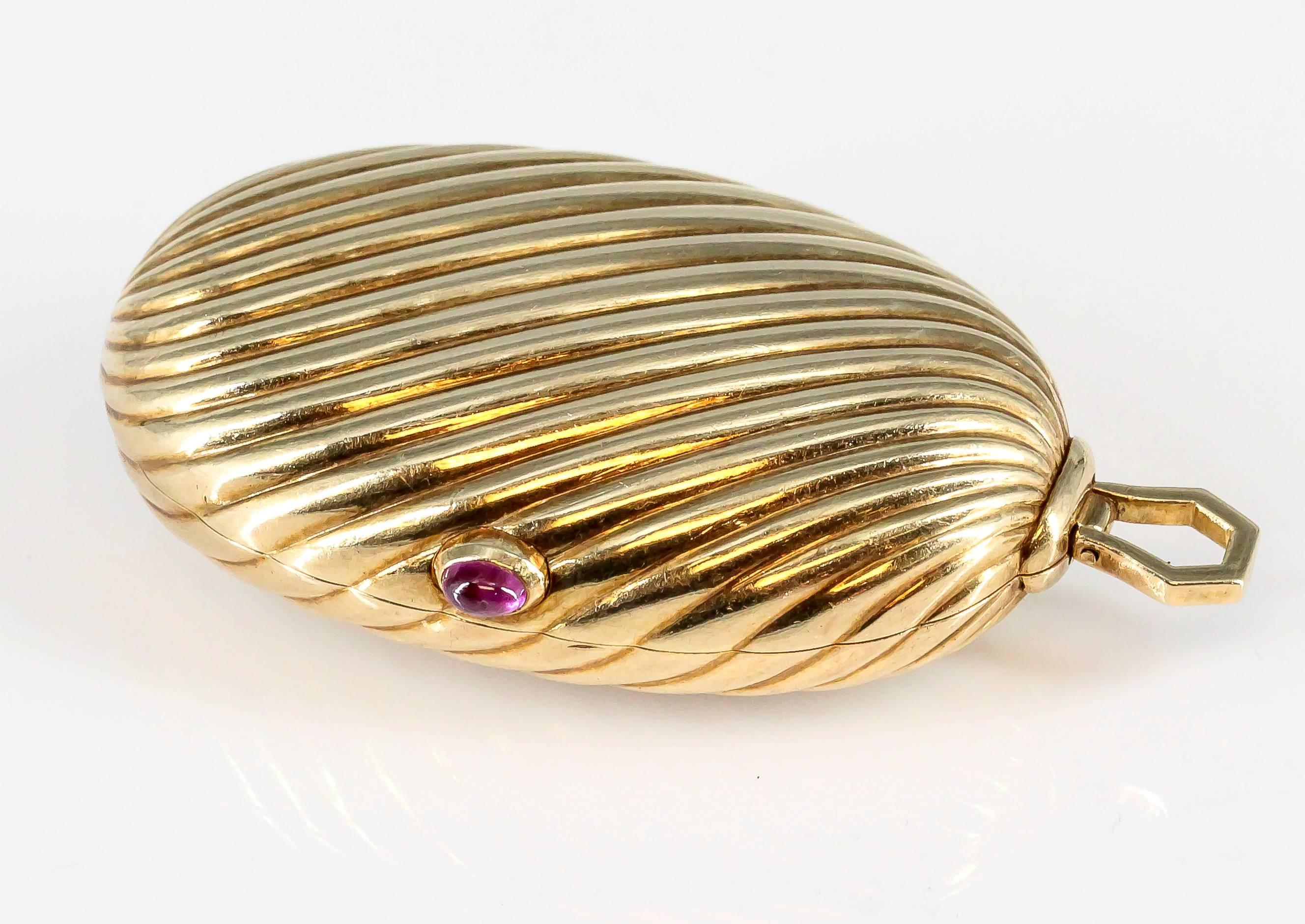 Elegant ruby and 18K yellow gold ribbed pill box by Bulgari. It features a cabochon ruby as an opening button, on an elliptical ribbed design commonly known as the Mellon. Beautifully made and ease to use.

Hallmarks: Bulgari, 750, maker's mark.