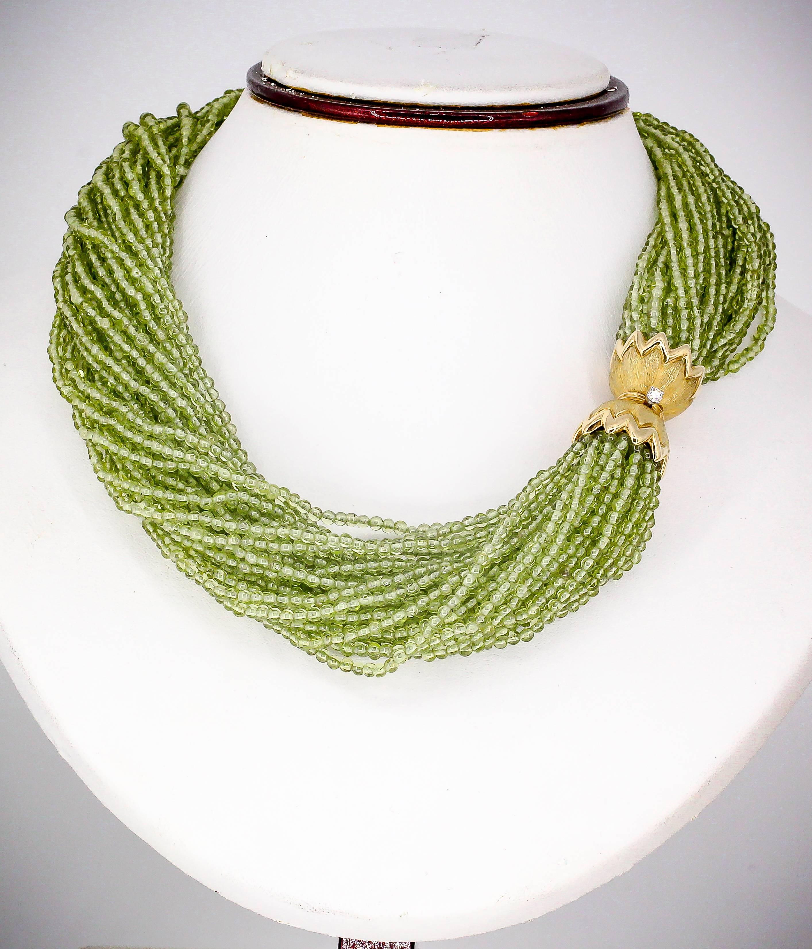 Sophisticated diamond, peridot and 18K yellow gold necklace and bracelet combination by Tiffany & Co. Schlumberger. It features interchangeable clasps so you can connect each one to make a larger necklace. Numerous intertwined strands of peridot