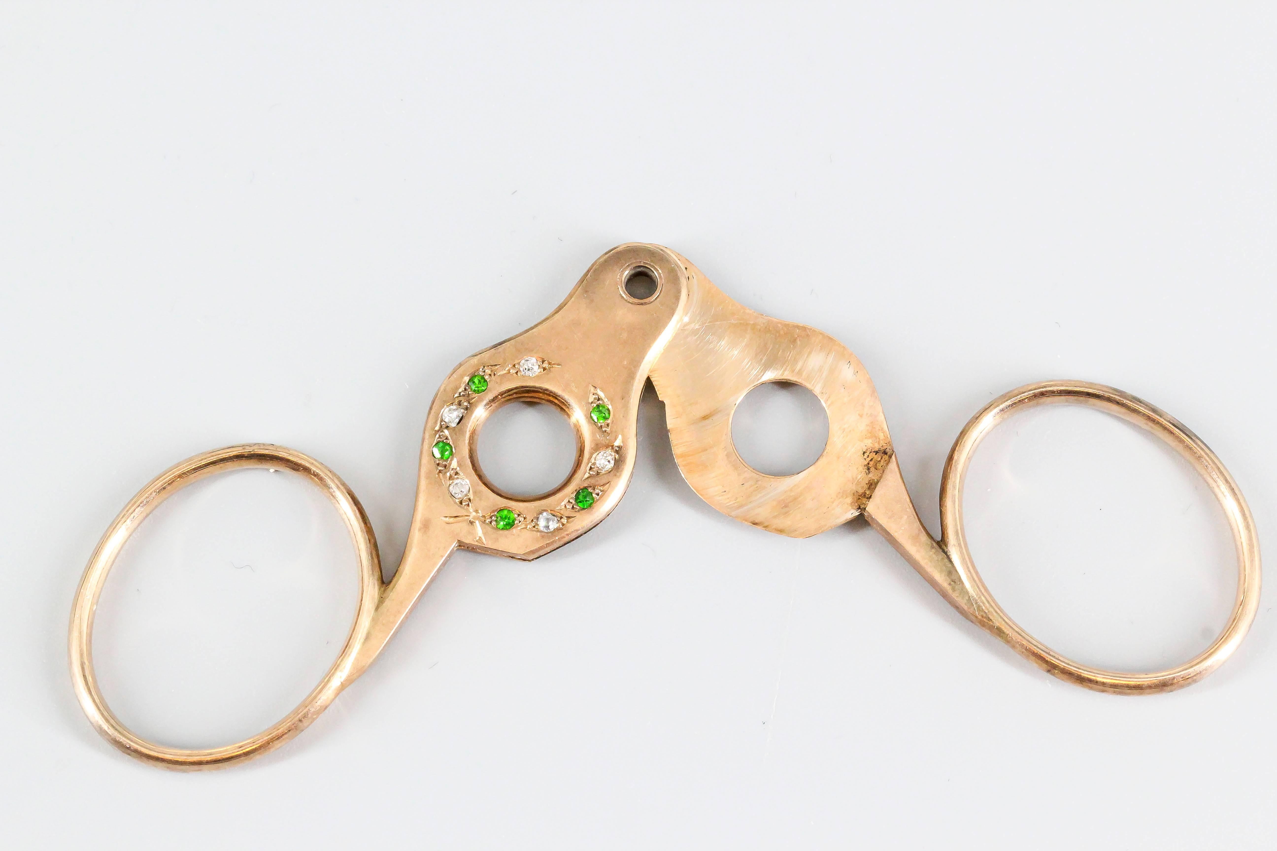 Chic diamond, emerald and rose gold cigar cutter, circa 1890s. It features high grade round cut diamonds and emeralds on one side. 
