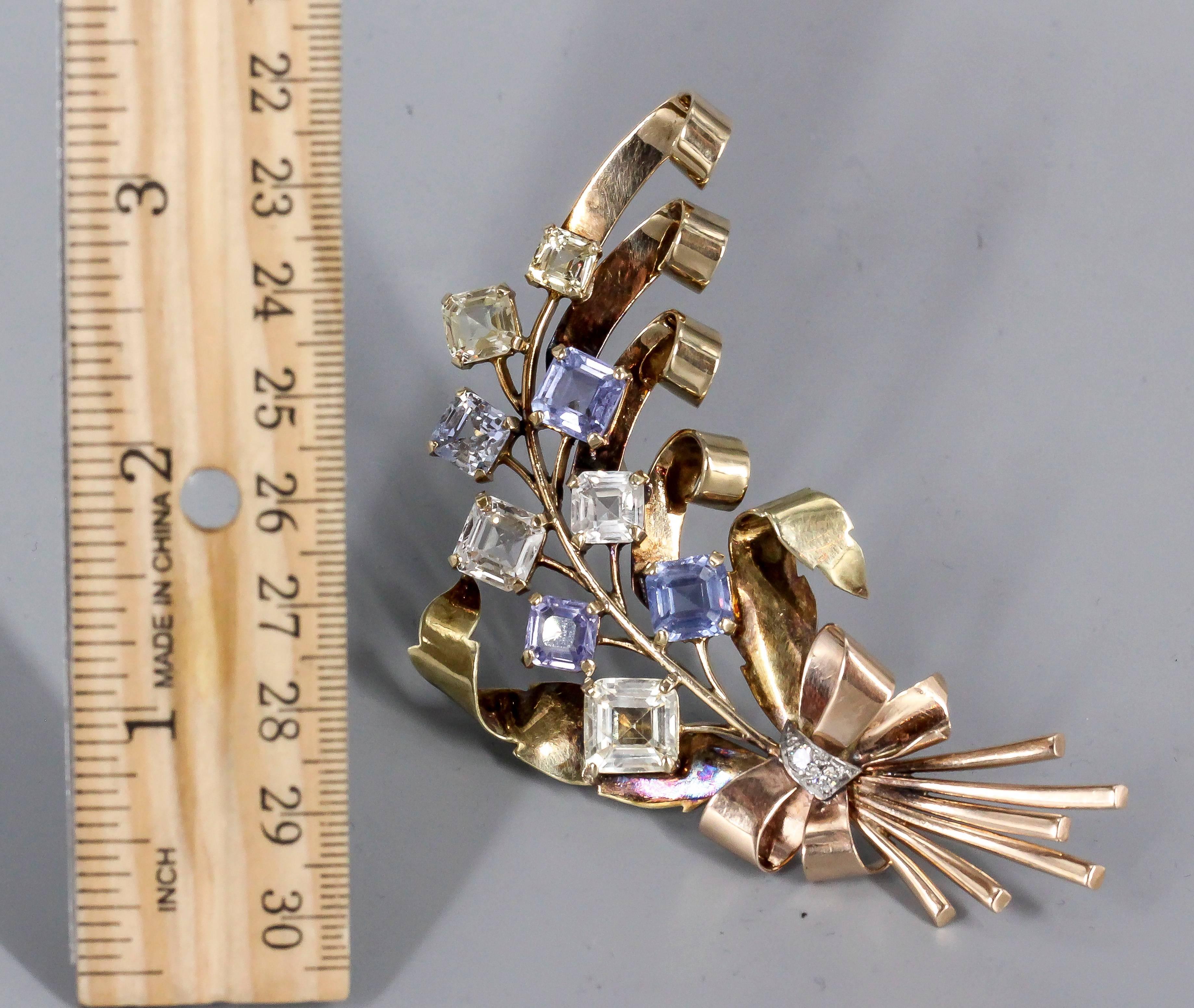 Elegant blue and yellow sapphire brooch, circa 1940s. Set in 14k yellow and pink gold, it features approx. 25 carats of colored sapphires with two round cut diamonds at the base of the brooch. True period piece that makes a statement.