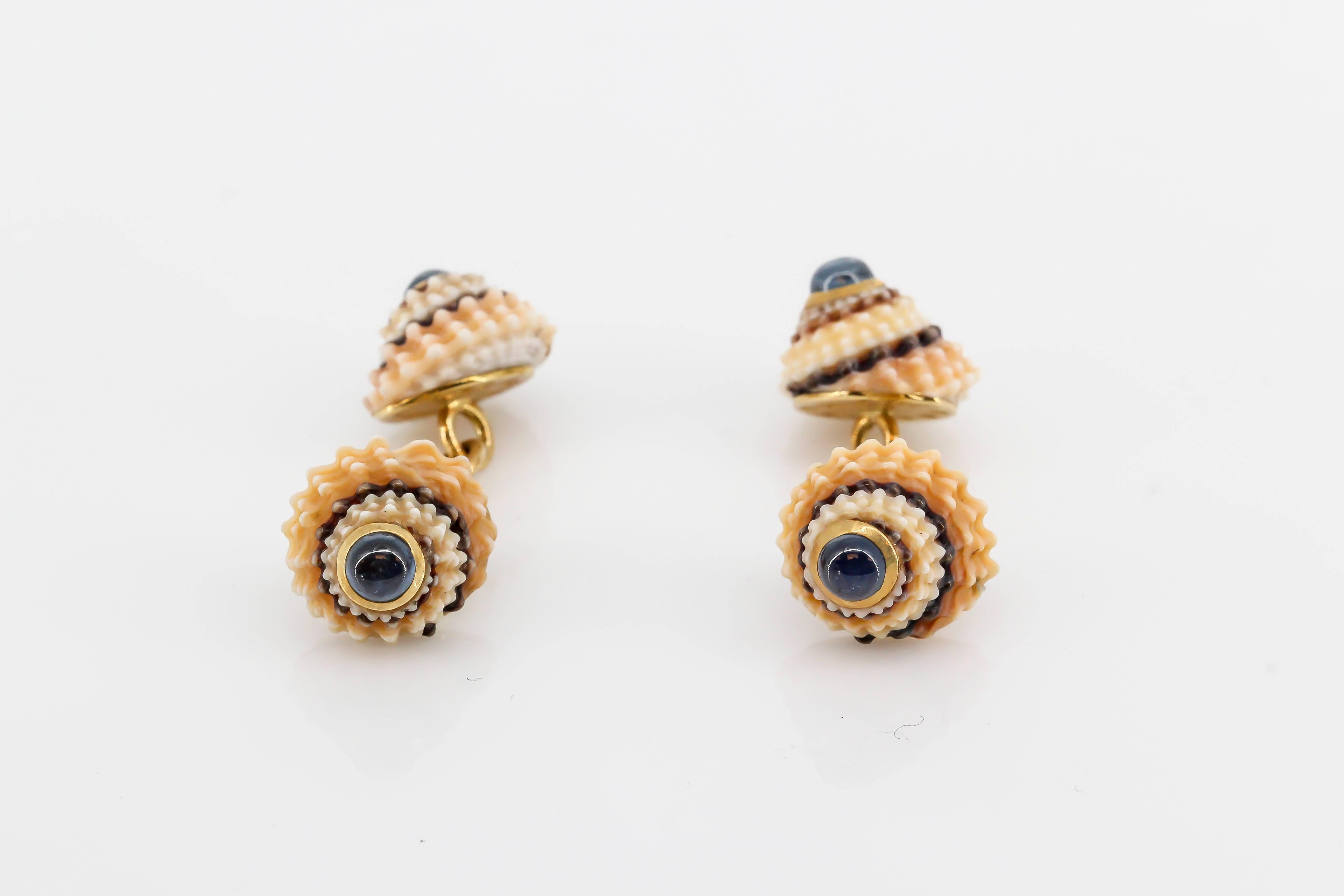 Whimsical blue sapphire, 18K yellow gold and sea shell cufflinks by Trianon. They feature cabochon sapphires on each end with a stylish sea shell design. Beautifully made and easy to wear. Original retail price $4350.

Hallmarks: Trianon, reference