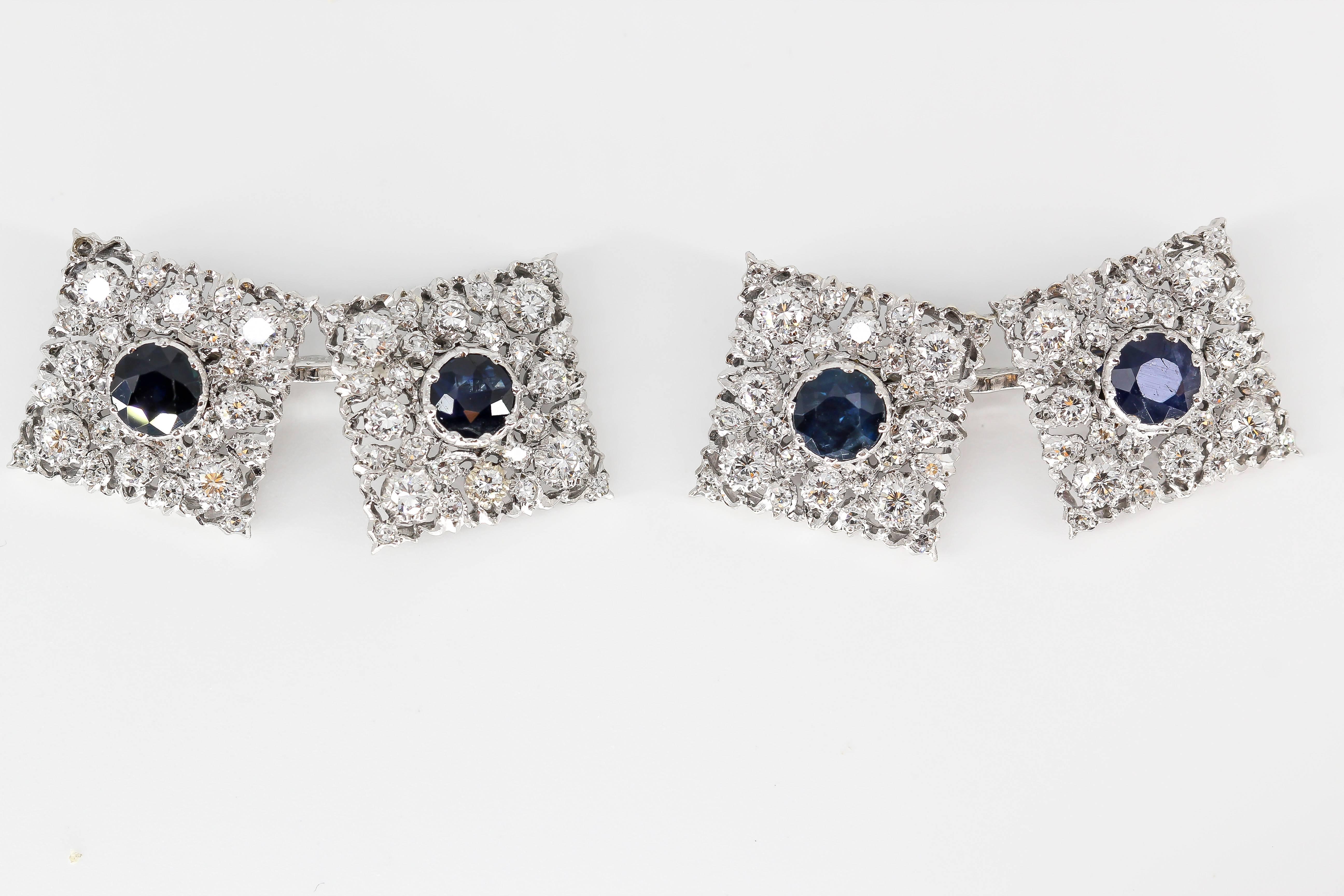 Dazzling blue sapphire, diamond and 18K white gold square cufflinks by Mario Buccellati. They feature rich round blue sapphires at the center, surrounded by high grade round brilliant cut diamonds in an intricate gold lattice setting that has been a