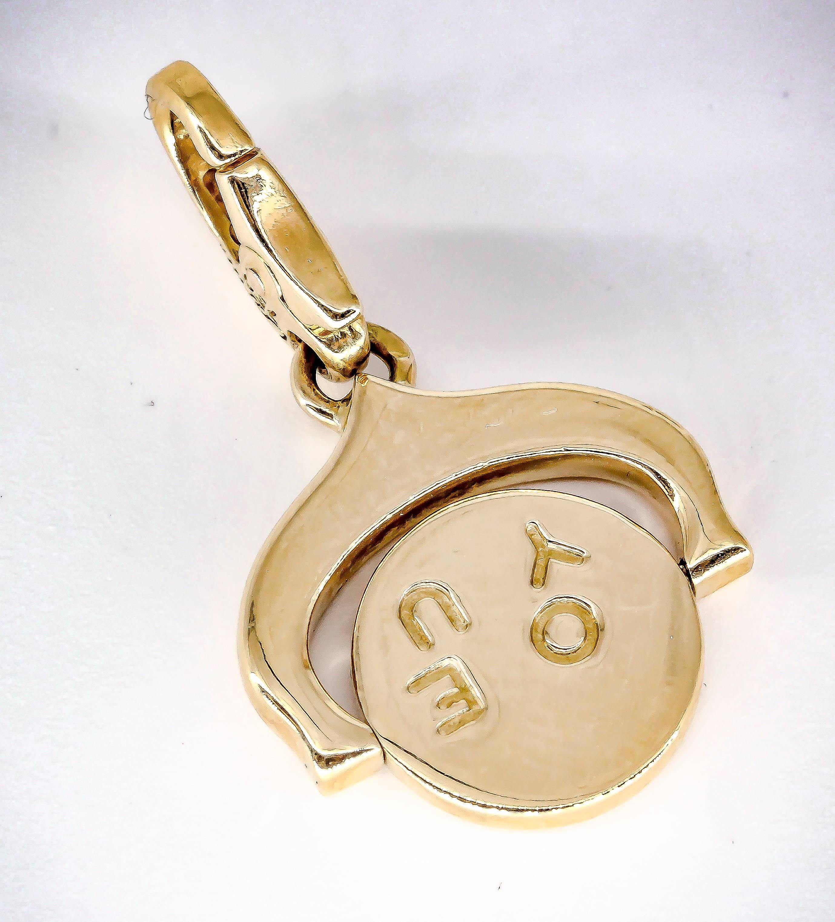 Interesting 18K yellow gold charm by Cartier. It has a revolving circle that when spun reads 