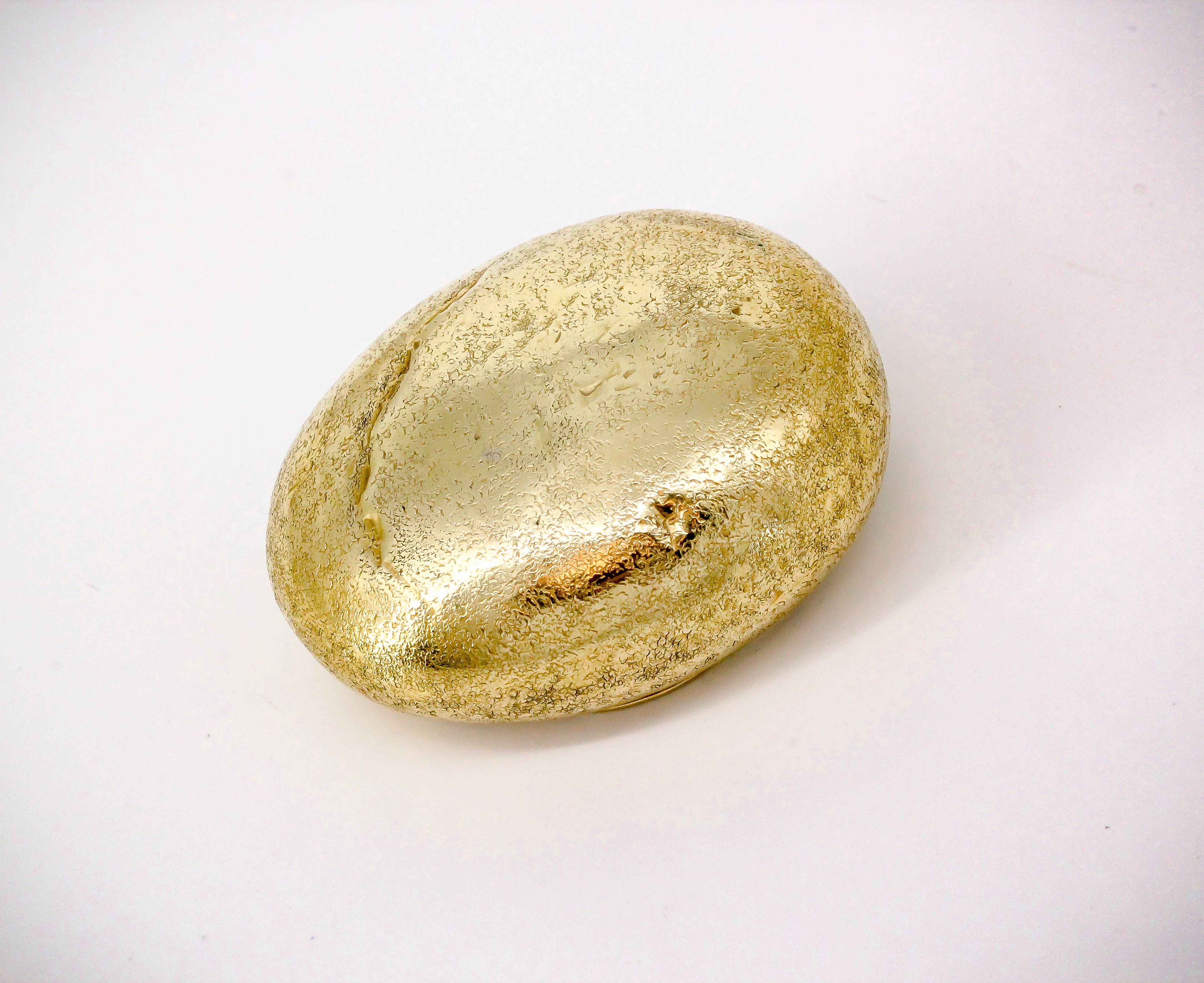 Whimsical 18K yellow gold pill box by Tiffany & Co. Schlumberger. It resembles an oval pebble, or rock. Beautifully made with an uneven textured look to resemble all the grooves and cuts in the rock. With a flat base. Superb