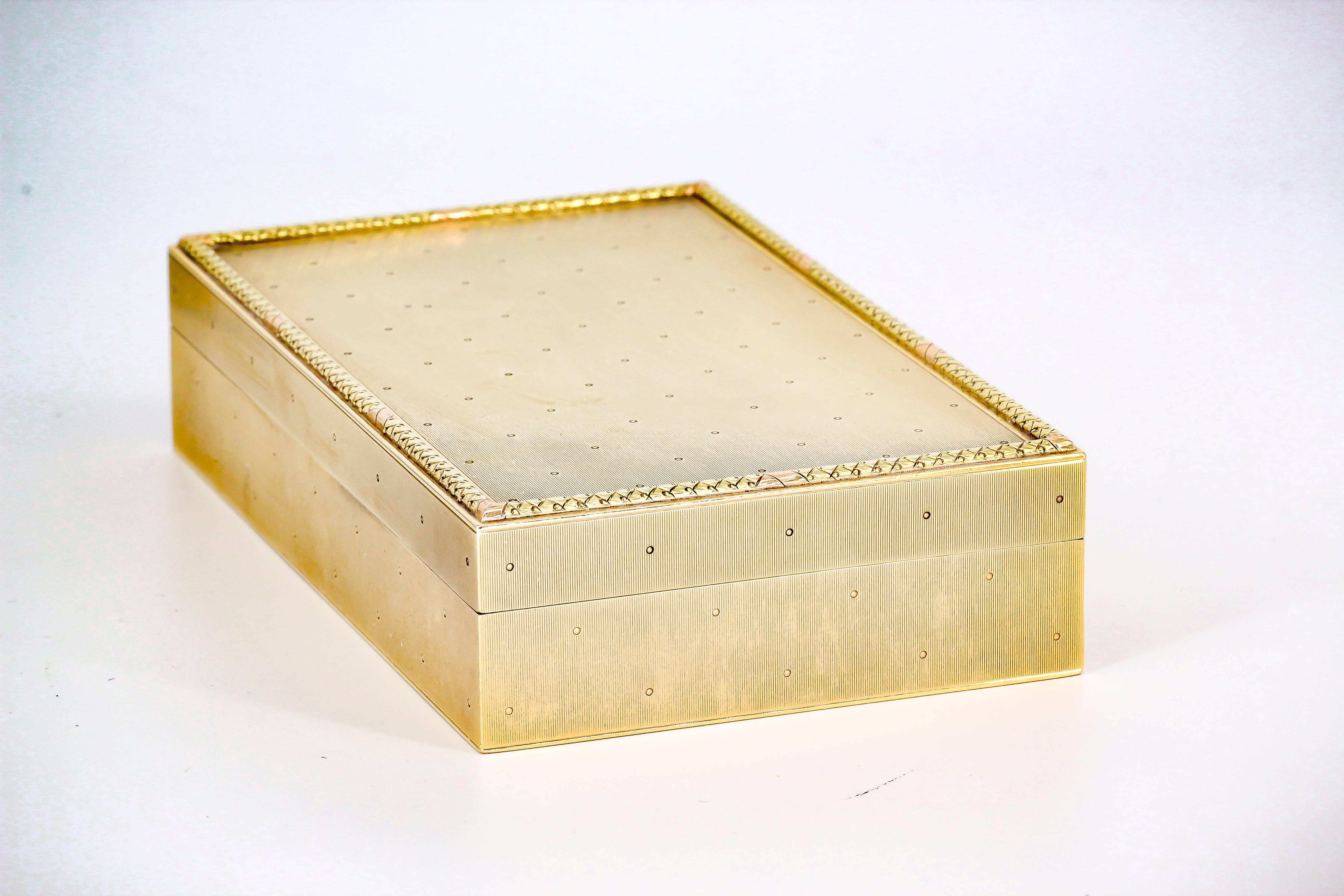 Handsome 14k yellow gold cigar box by Cartier, circa 1930s. It features a rather simple layout, with adorned outer border on top lid. Surface is ribbed and feels almost textured to the touch. Beautifully made and a great display piece.

Hallmarks:
