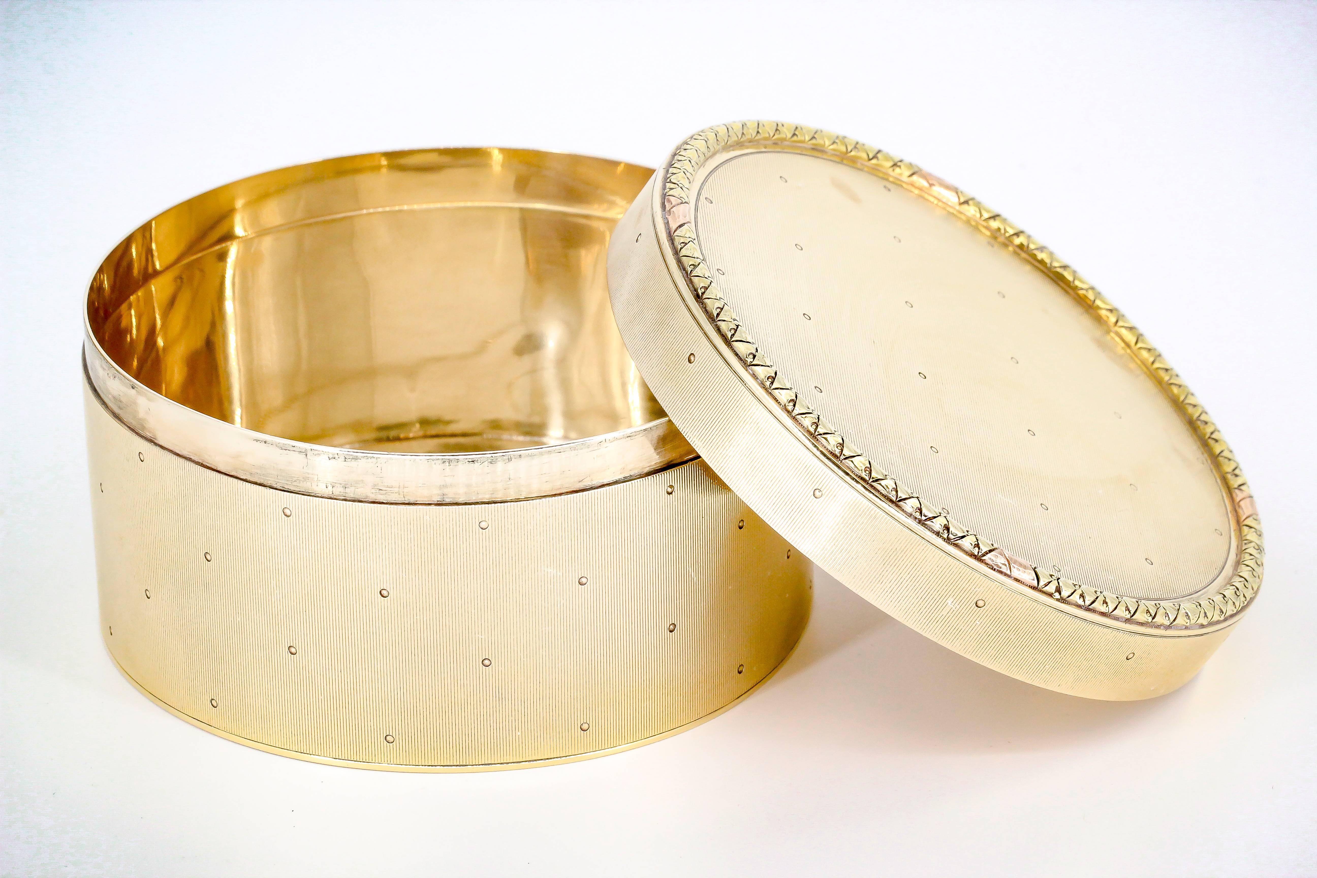 Elegant 14K yellow gold round box by Cartier, circa 1930s. It features a subtly ribbed surface with small dots throughout, and an intricate design around the outer edge of the top lid. Beautifully made and a great display piece.

Hallmarks: Cartier,
