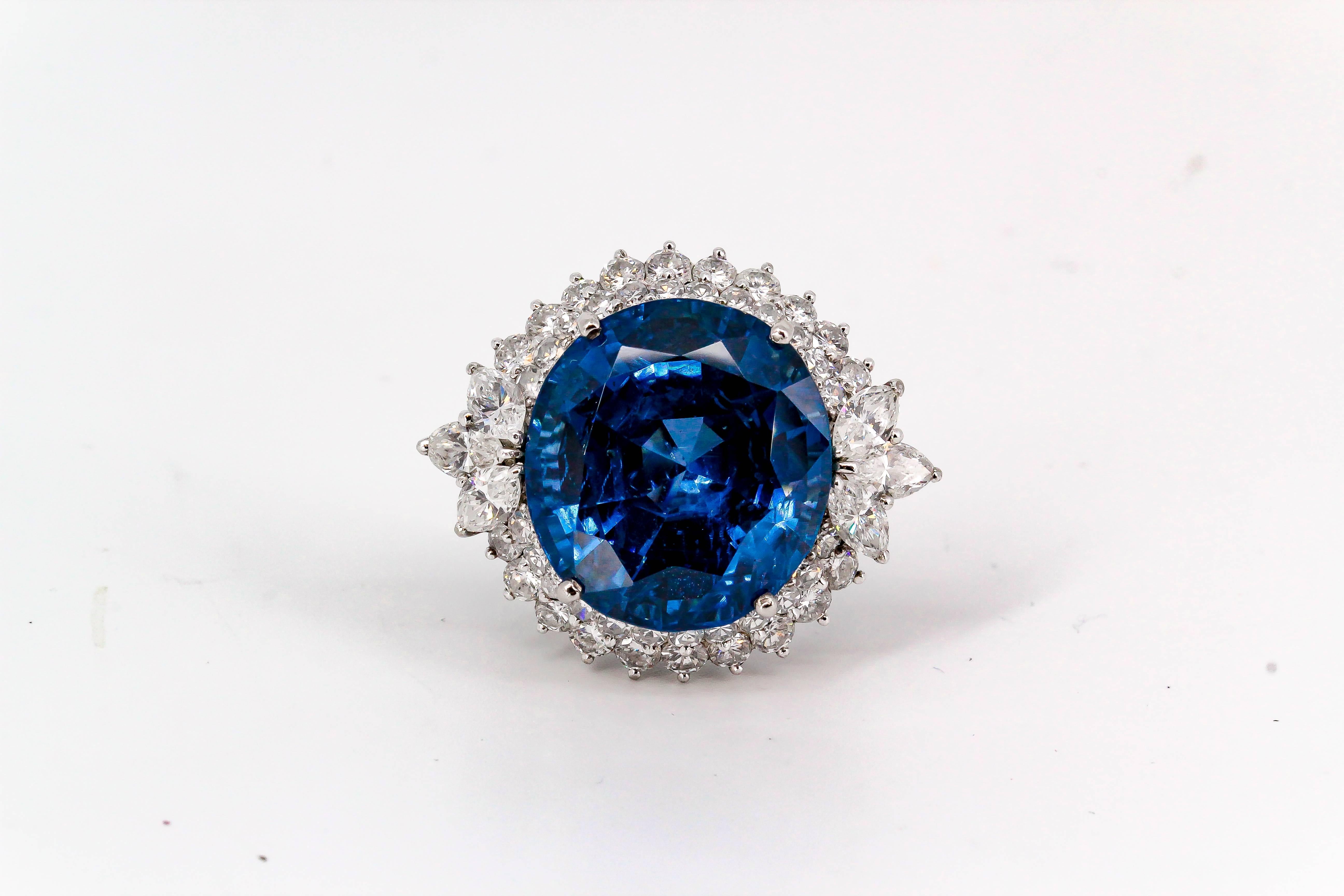 Impressive royal blue Burma sapphire, diamond and platinum dome ring. It features a rich blue central sapphire, AGL certified measuring 17.62x16.17x11.19mm for a total of approx. 26cts. It is surrounded by high grade round and Marquise cut diamonds