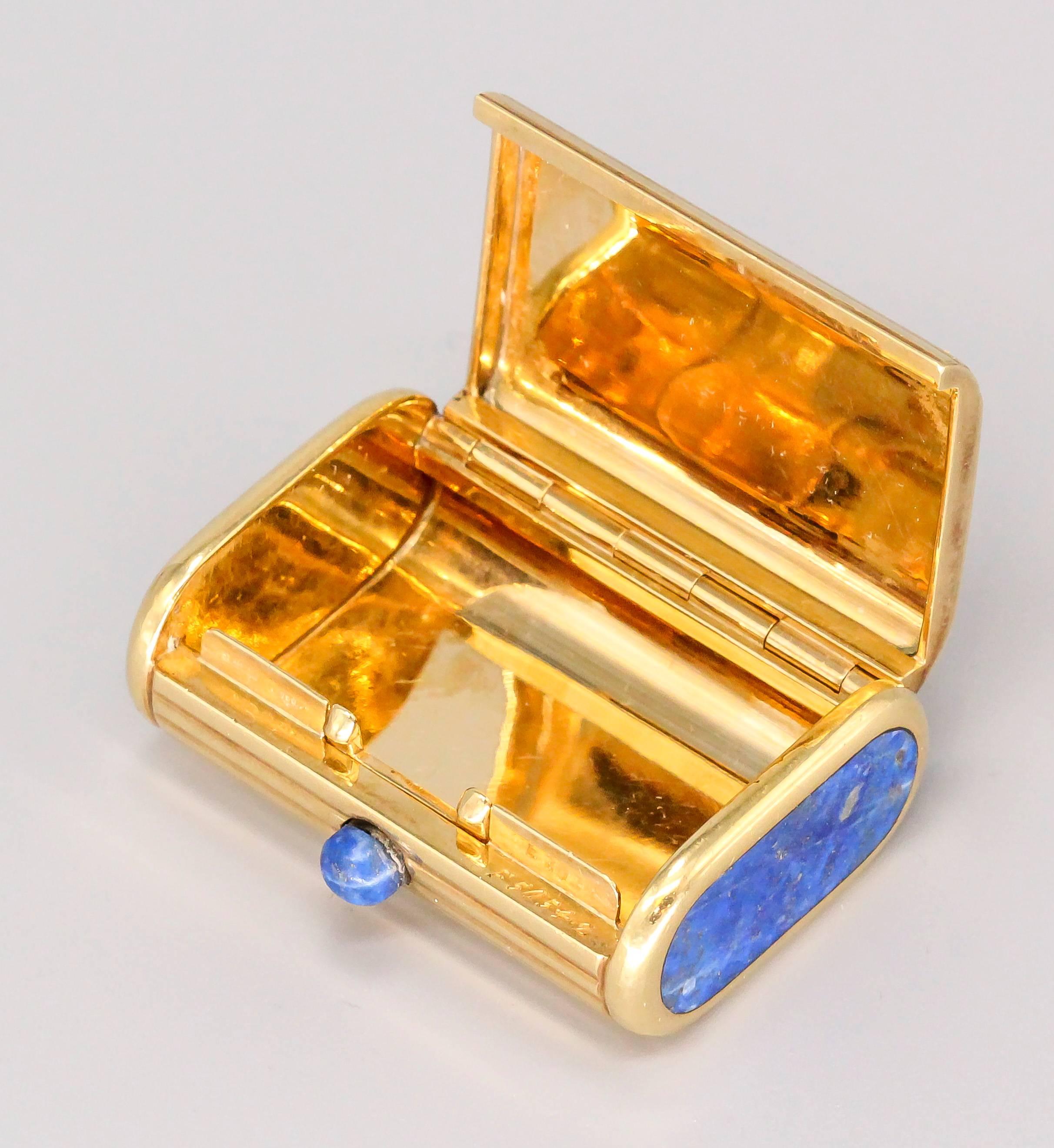 Interesting lapis and 18K yellow gold ribbed pill box of Italian origin. It features a lapis push button that releases a spring loaded lid.
Hallmarks: 750, Italian standard marks, reference numbers.