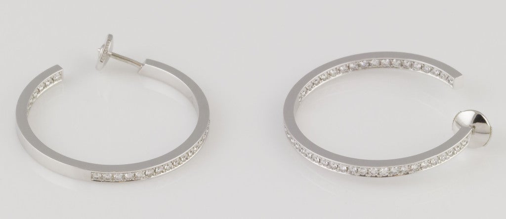 Beautiful 18K white gold and diamond hoop earrings by Cartier. They feature an 